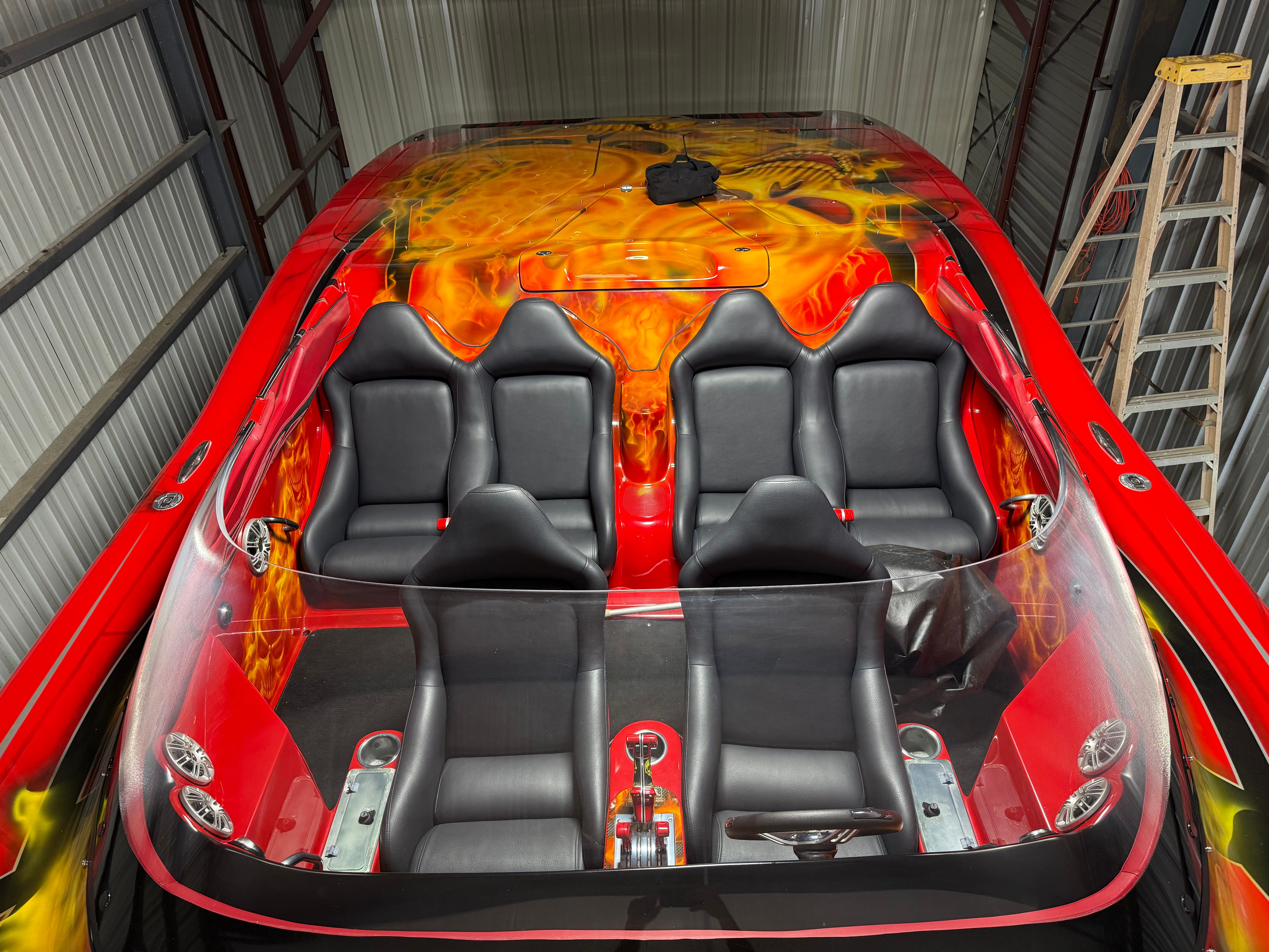 A 2010 MTI CAT with striking flame design and six black seats in a storage area.