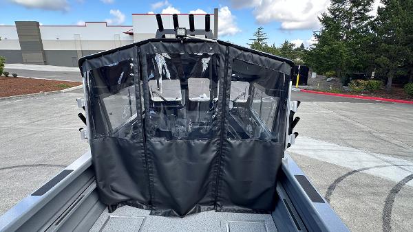 2024 Spartan 200 Astoria boat with protective cover, parked outdoors on a sunny day.