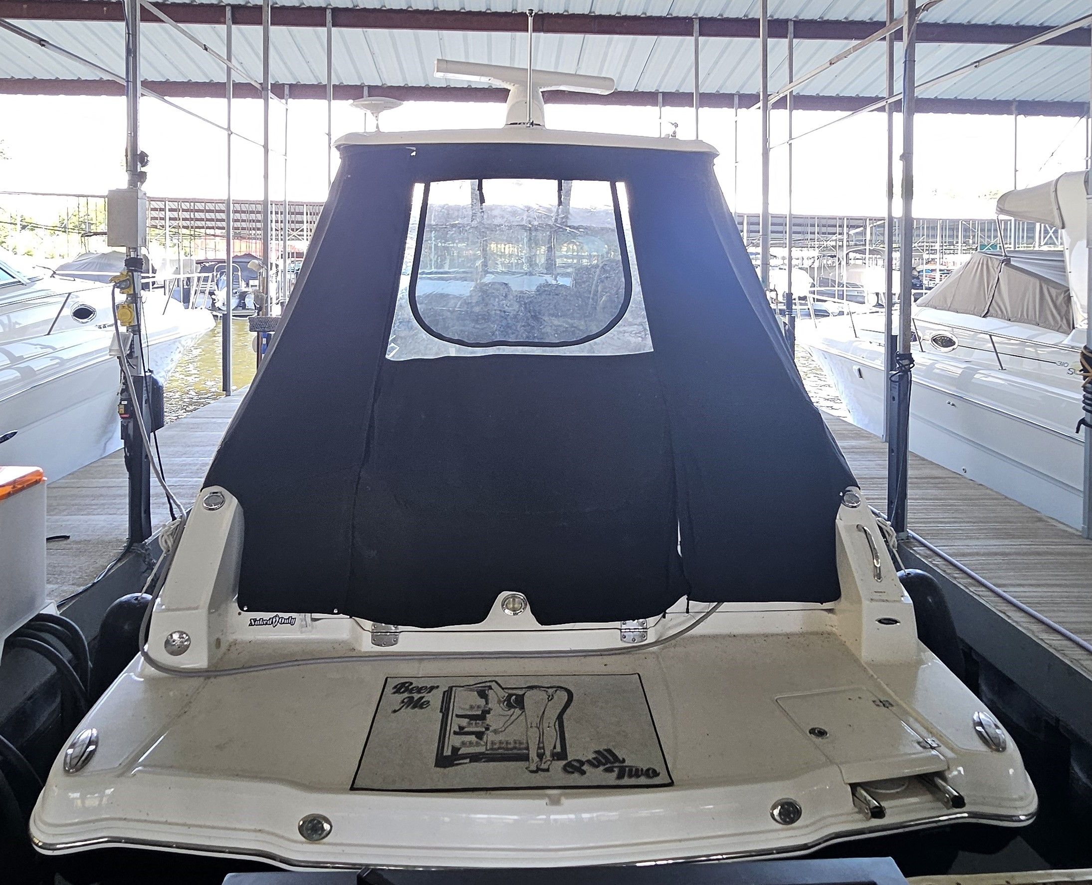 2014 Chaparral 330 Signature boat docked with black canopy.