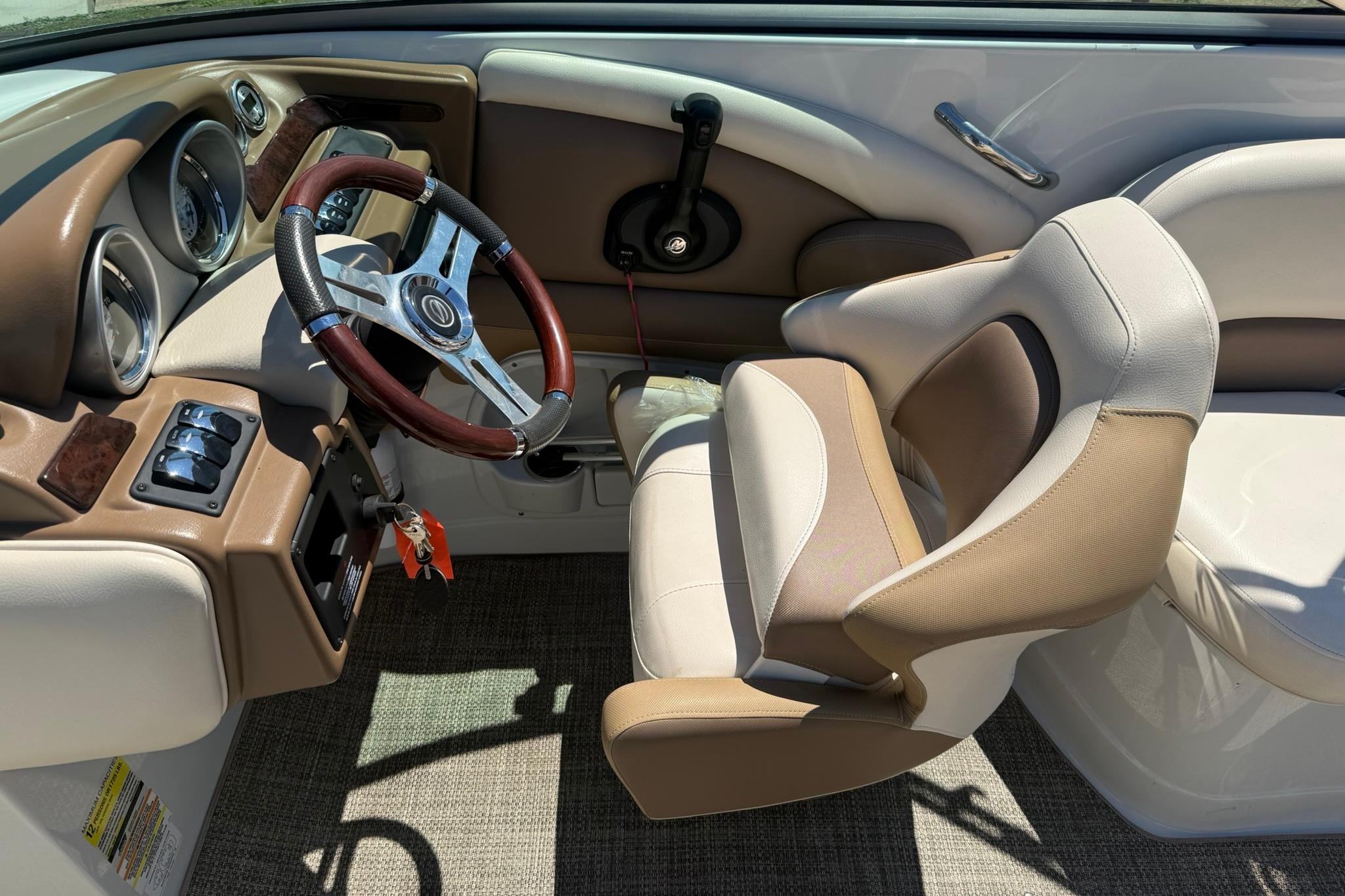 Interior of 2016 Crownline 255 SS boat, featuring steering wheel and captain's chair.