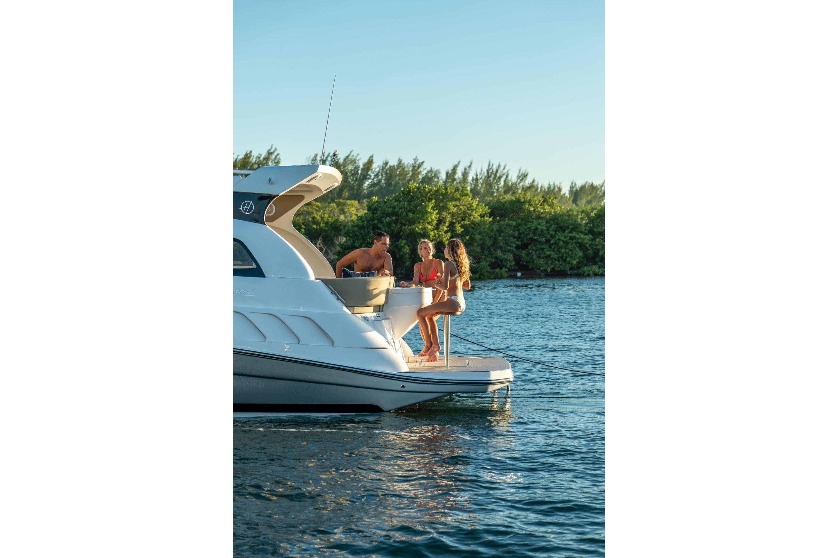 People enjoying leisure time on a 2026 Hanover 375 yacht by the water.