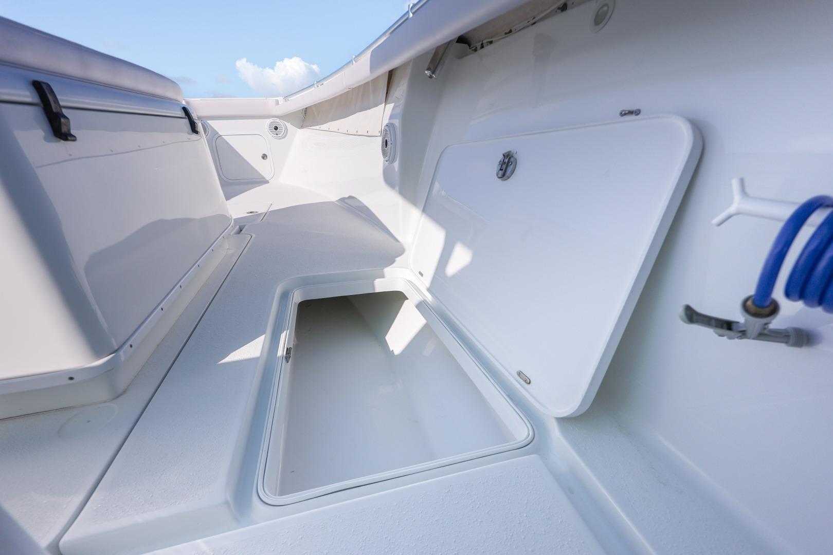 2018 Yellowfin 36 Offshore boat interior with storage compartments and hose.