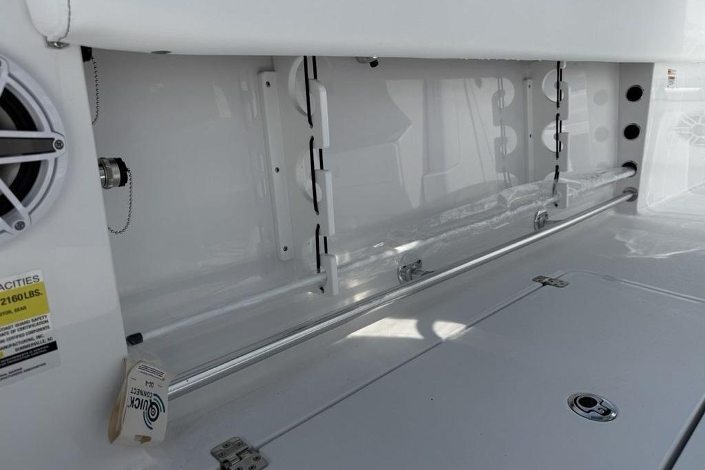 2026 Sportsman Open 252 Center Console interior storage compartment with speaker and safety label.