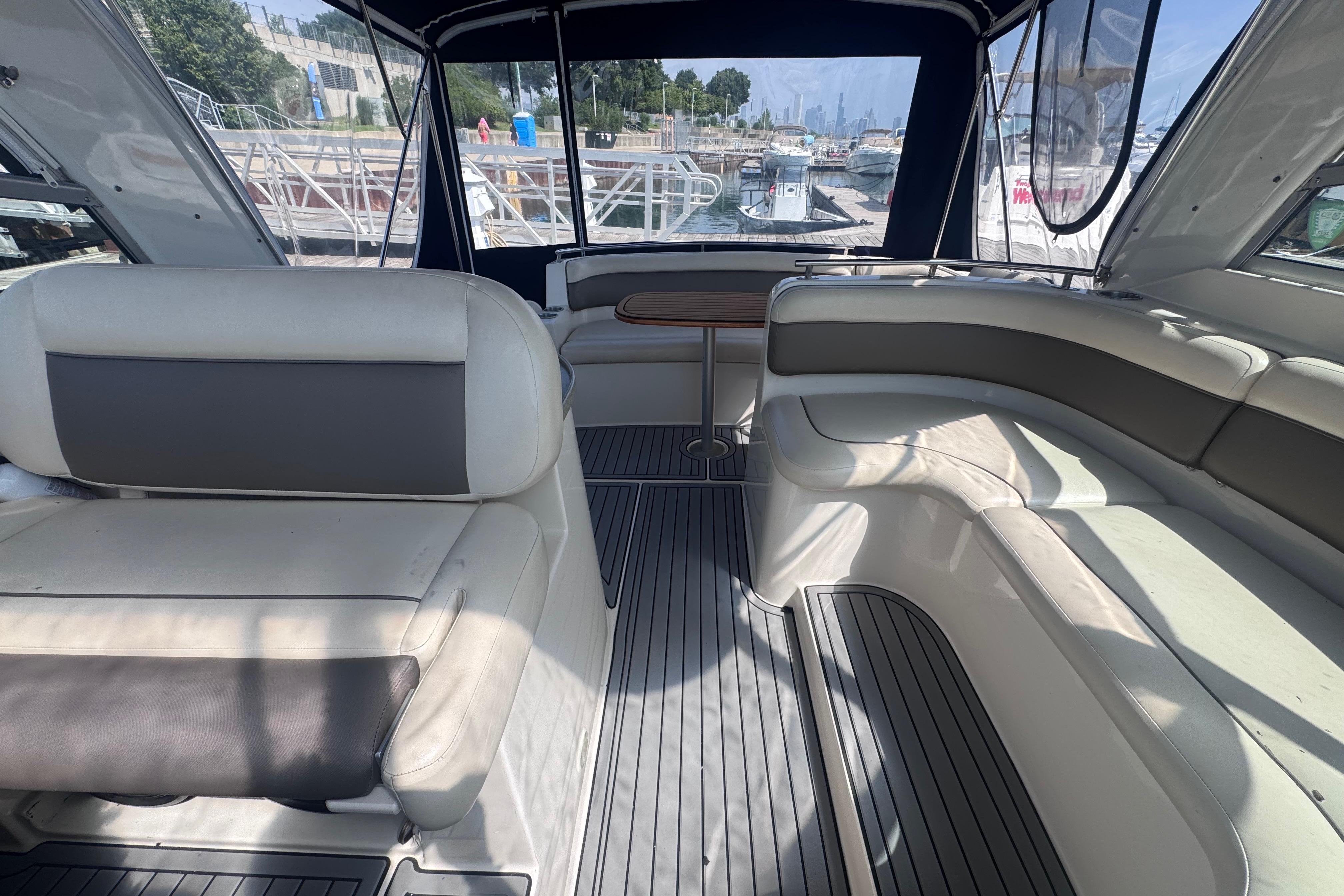 Interior of a 2003 Rinker Fiesta Vee 312 boat with spacious seating and dock view.