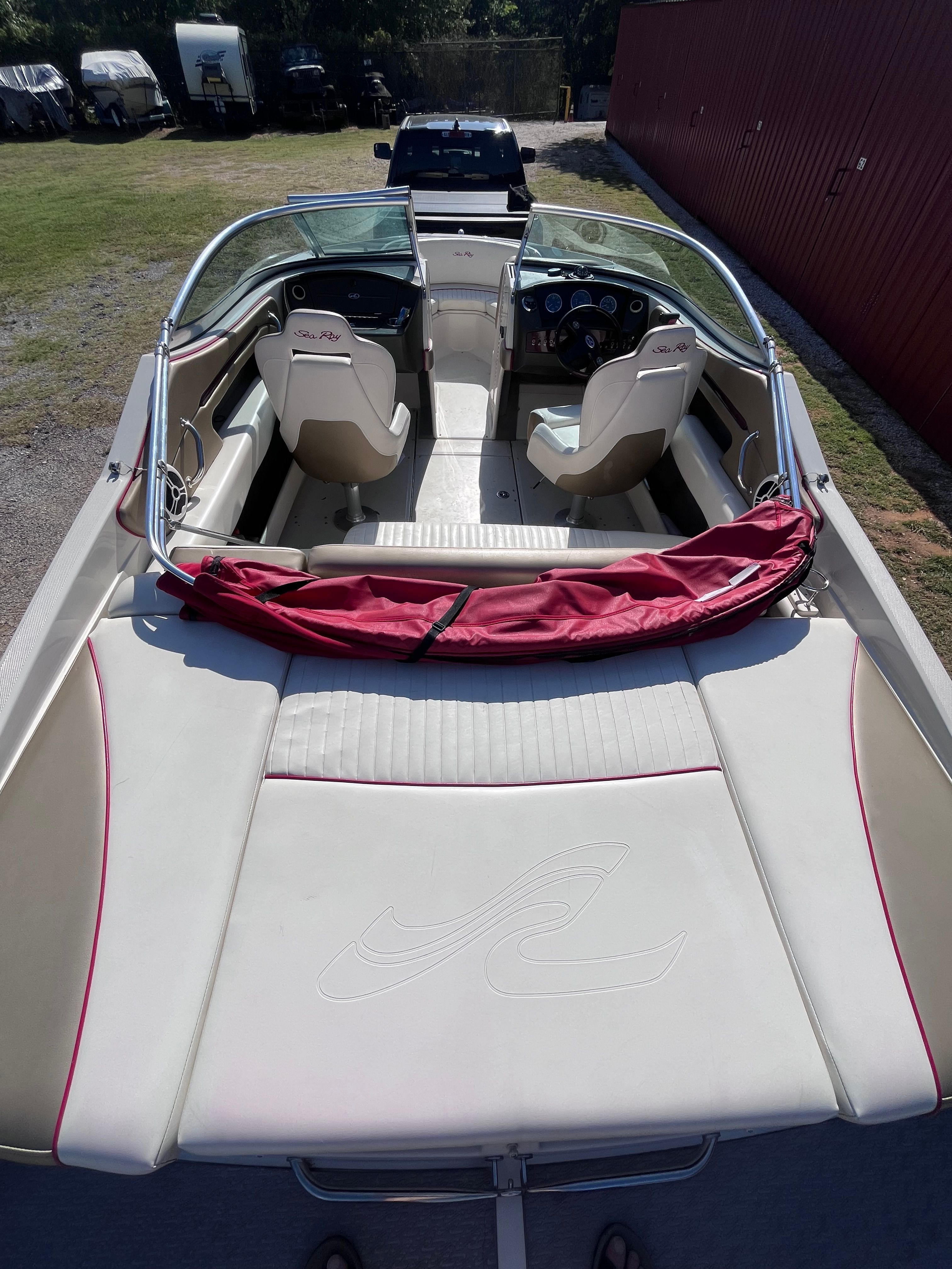 Interior view of a 2007 Sea Ray 210 Select boat with beige seats and a red cover.
