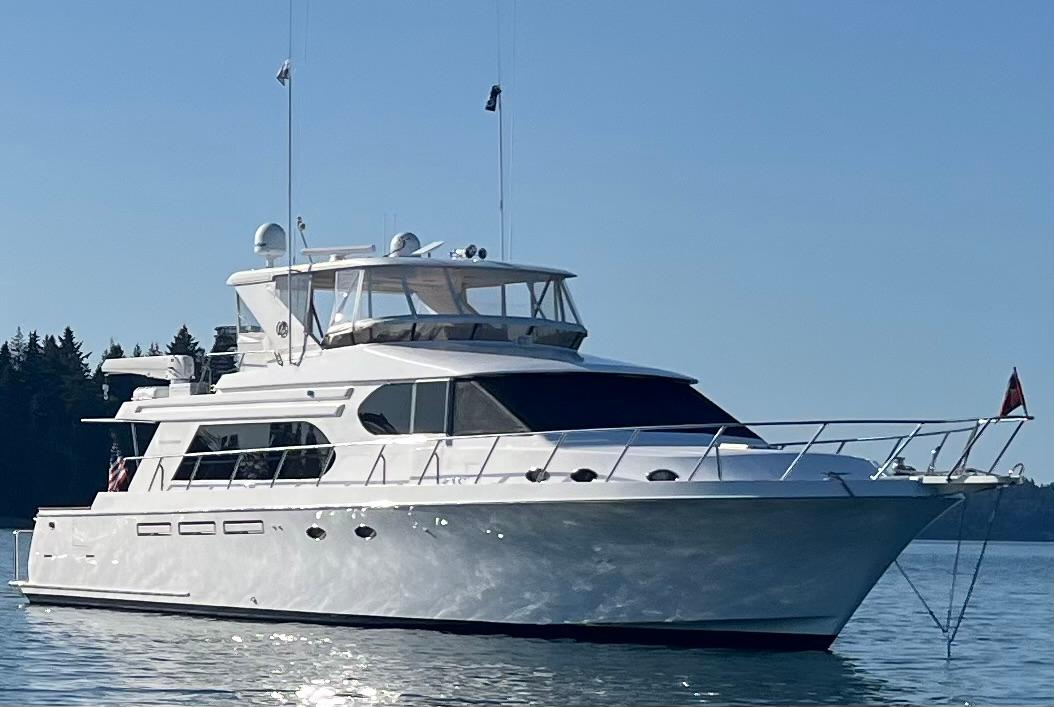 2004 Ocean Alexander 64 Pilothouse yacht on calm water, clear sky background.