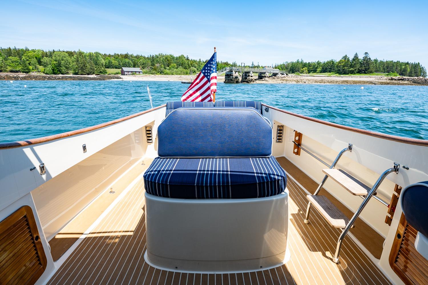 2001 Hinckley Picnic Boat 36 Classic on water, featuring striped seating and American flag.