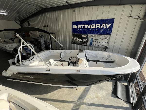 2025 Stingray 172SC boat displayed in showroom, featuring sleek black and white design.
