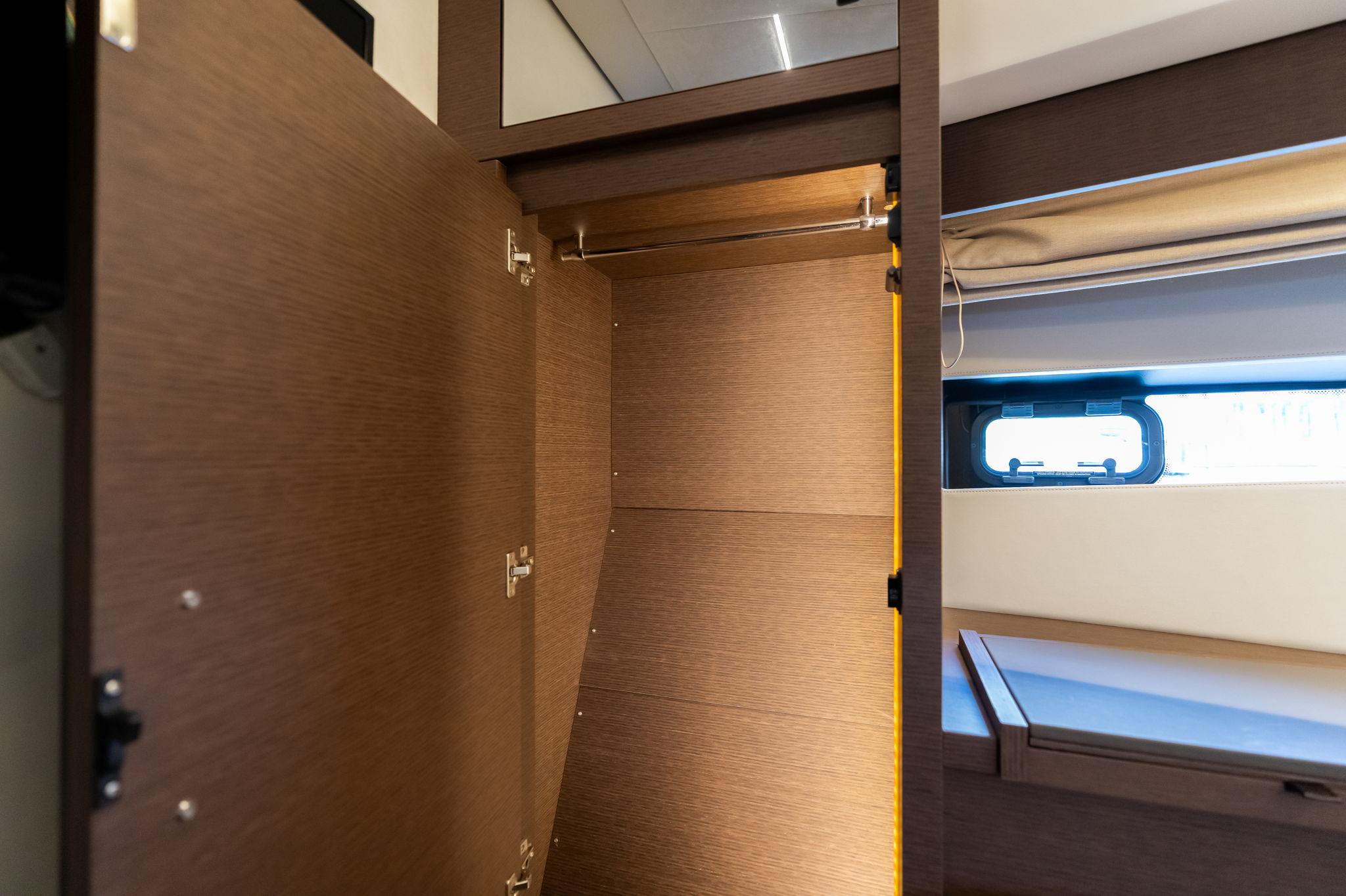 Empty wooden closet interior on a 2022 Prestige 520 yacht.