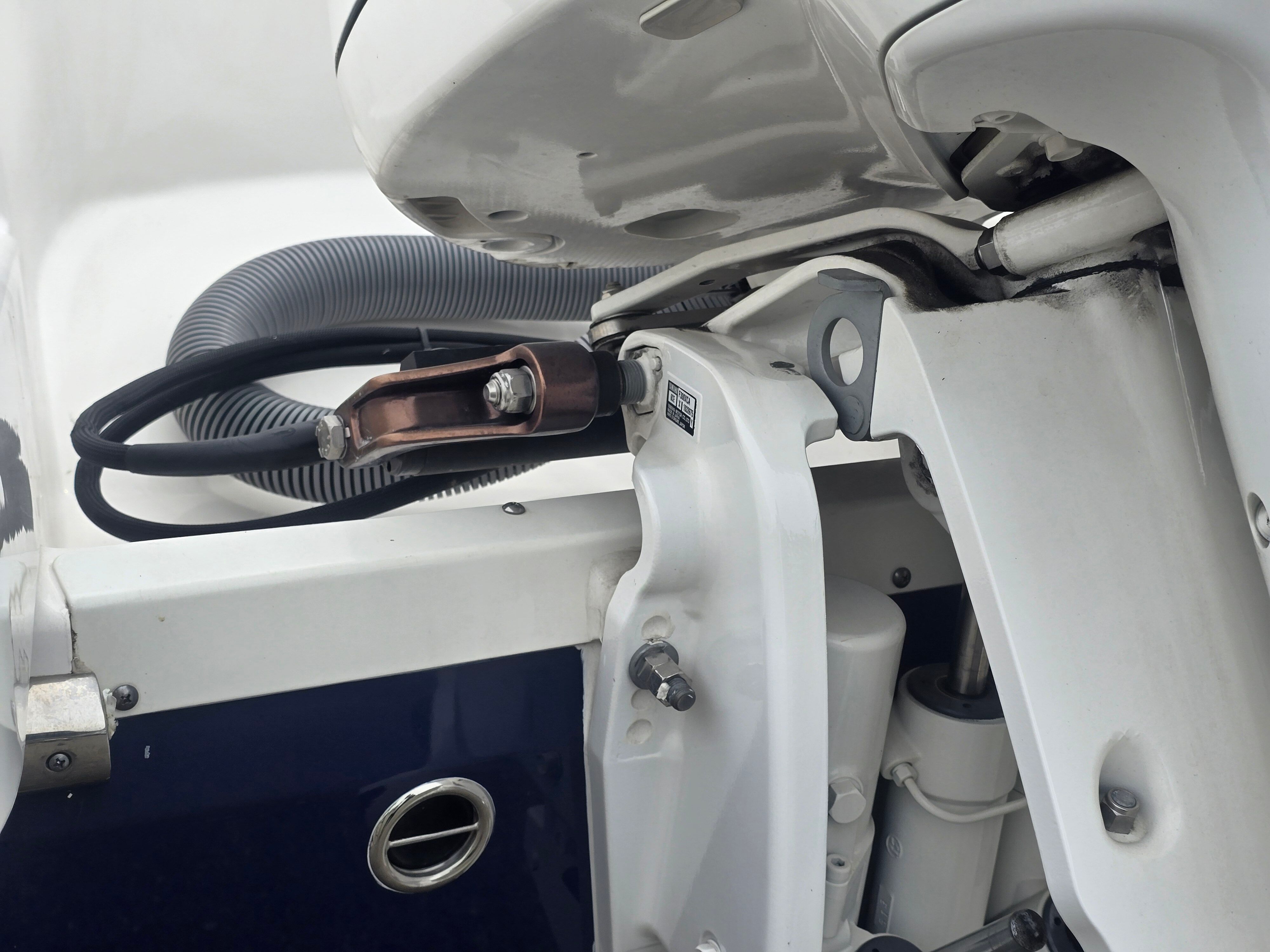 Close-up of a boat's outboard motor with cables and fittings.