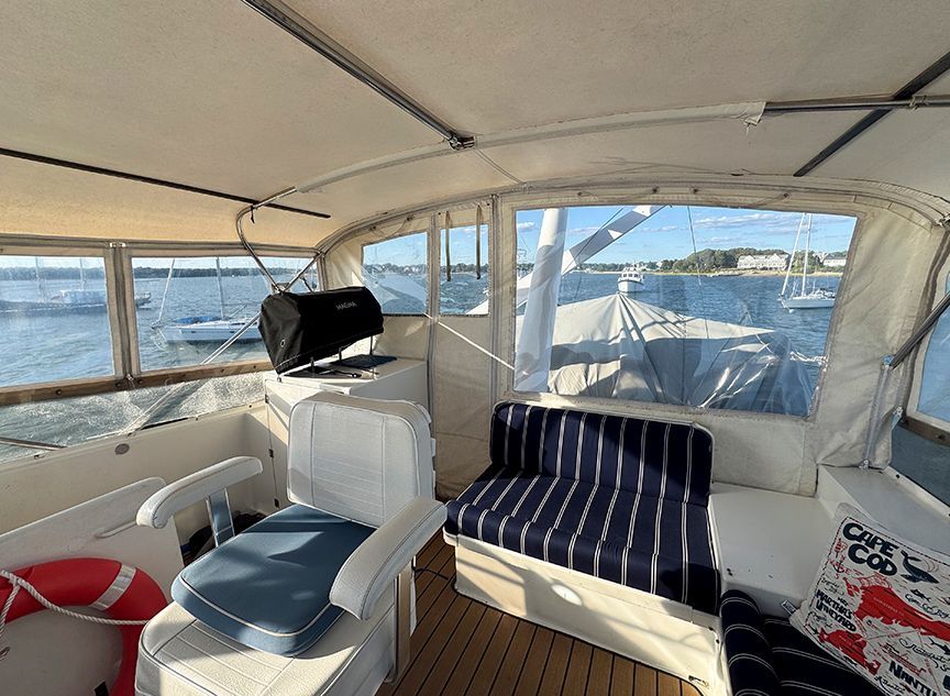The image shows the interior of a 1961 Burger 63 yacht with seating and a view of the water.