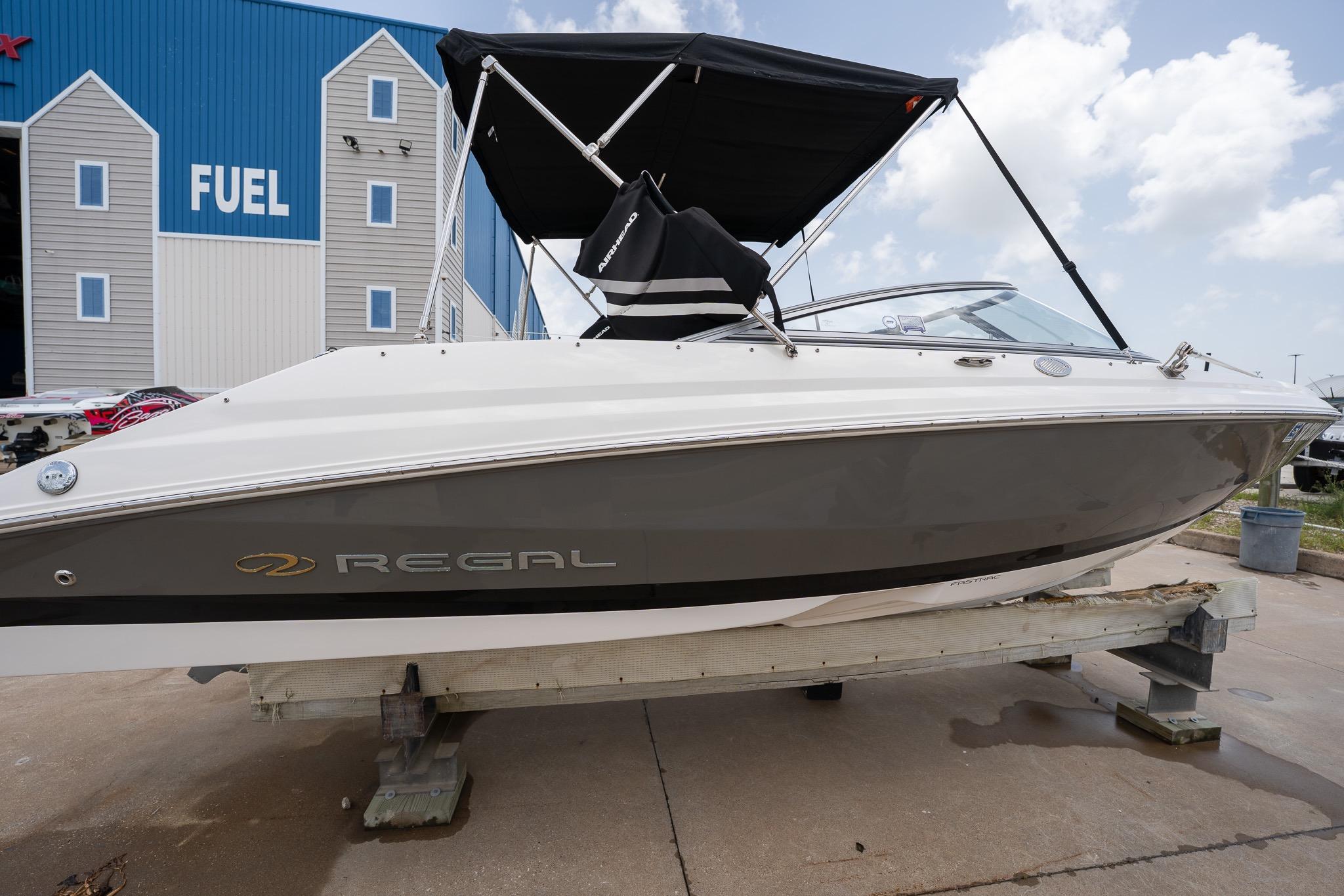 2008 Regal 2000 Bowrider boat with canopy, displayed outdoors near a fuel station.