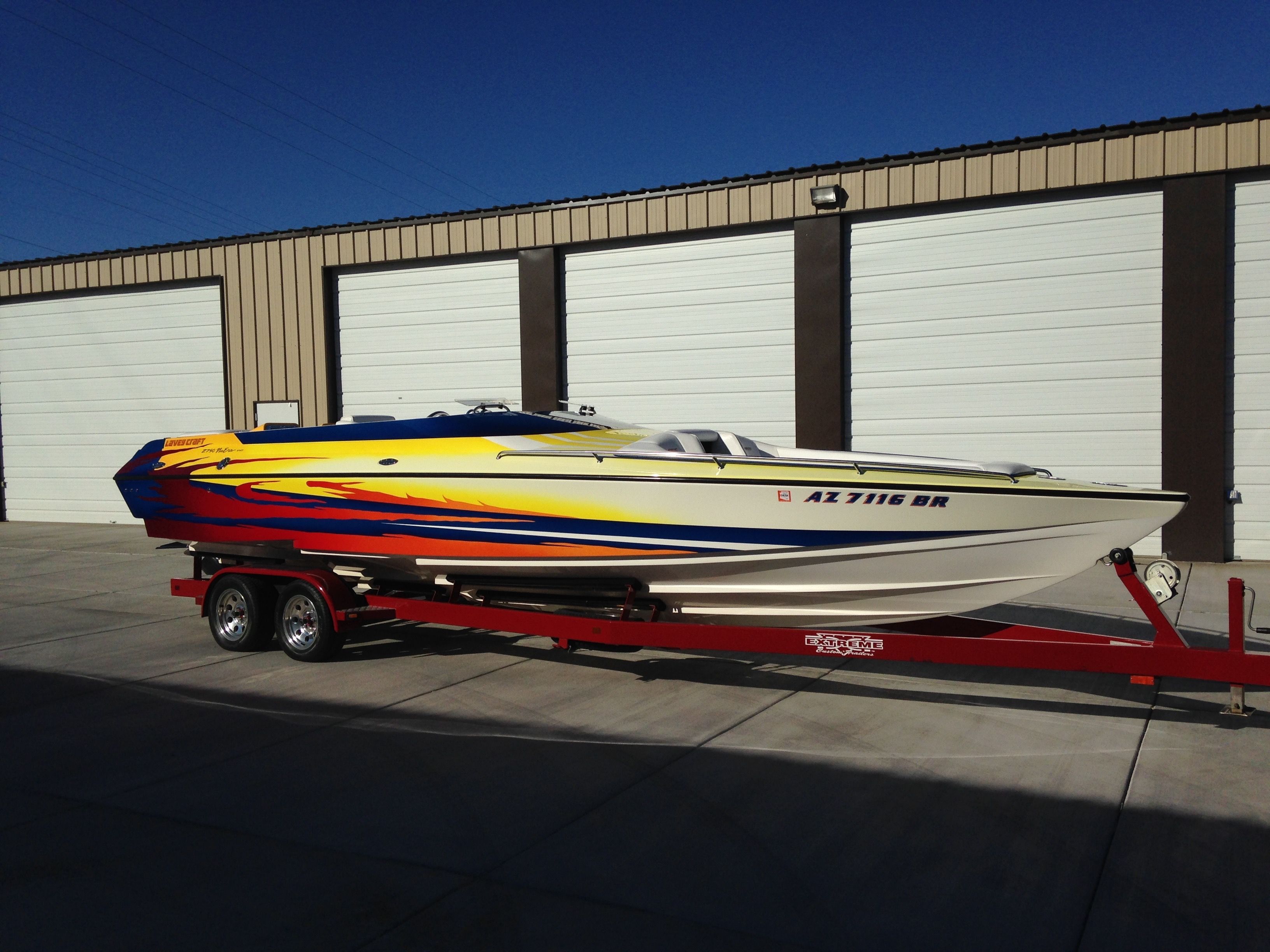 2002 Lavey Craft 2750 NUERA boat on trailer in front of garage.