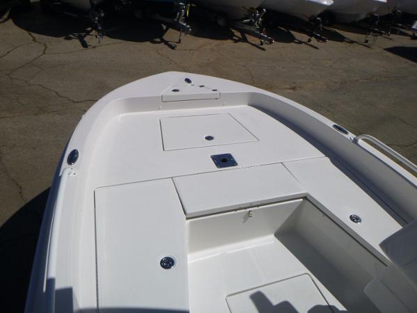 2024 Ranger 2360 Bay boat deck with storage compartments, shown in a marina setting.