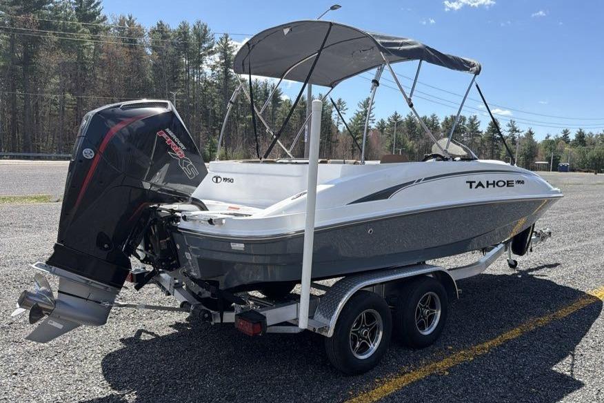 Tahoe 1950 boat on trailer, 2026 model, with outboard motor and canopy.