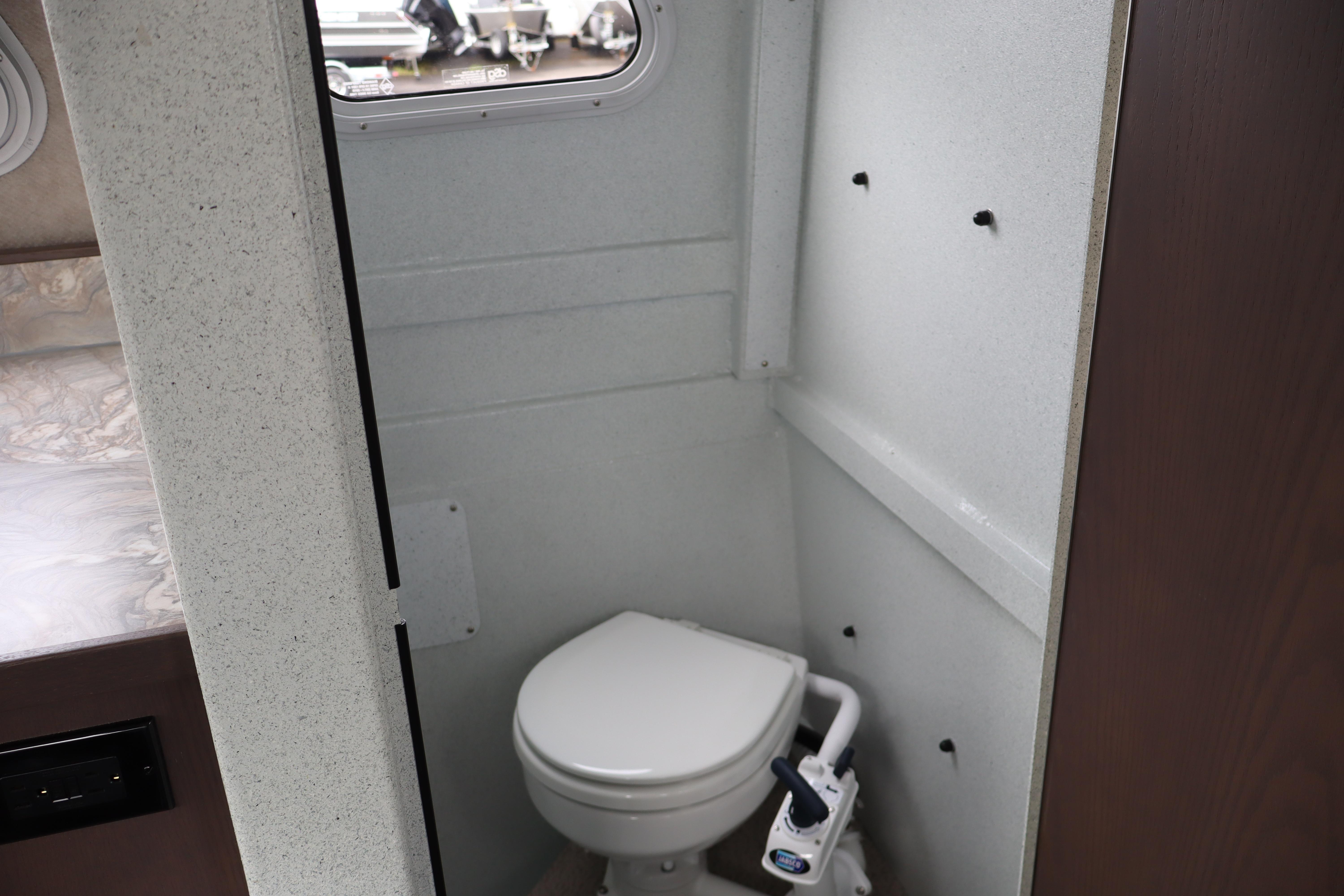 Compact bathroom in 2026 KingFisher 3025 XRS boat, featuring a modern toilet.