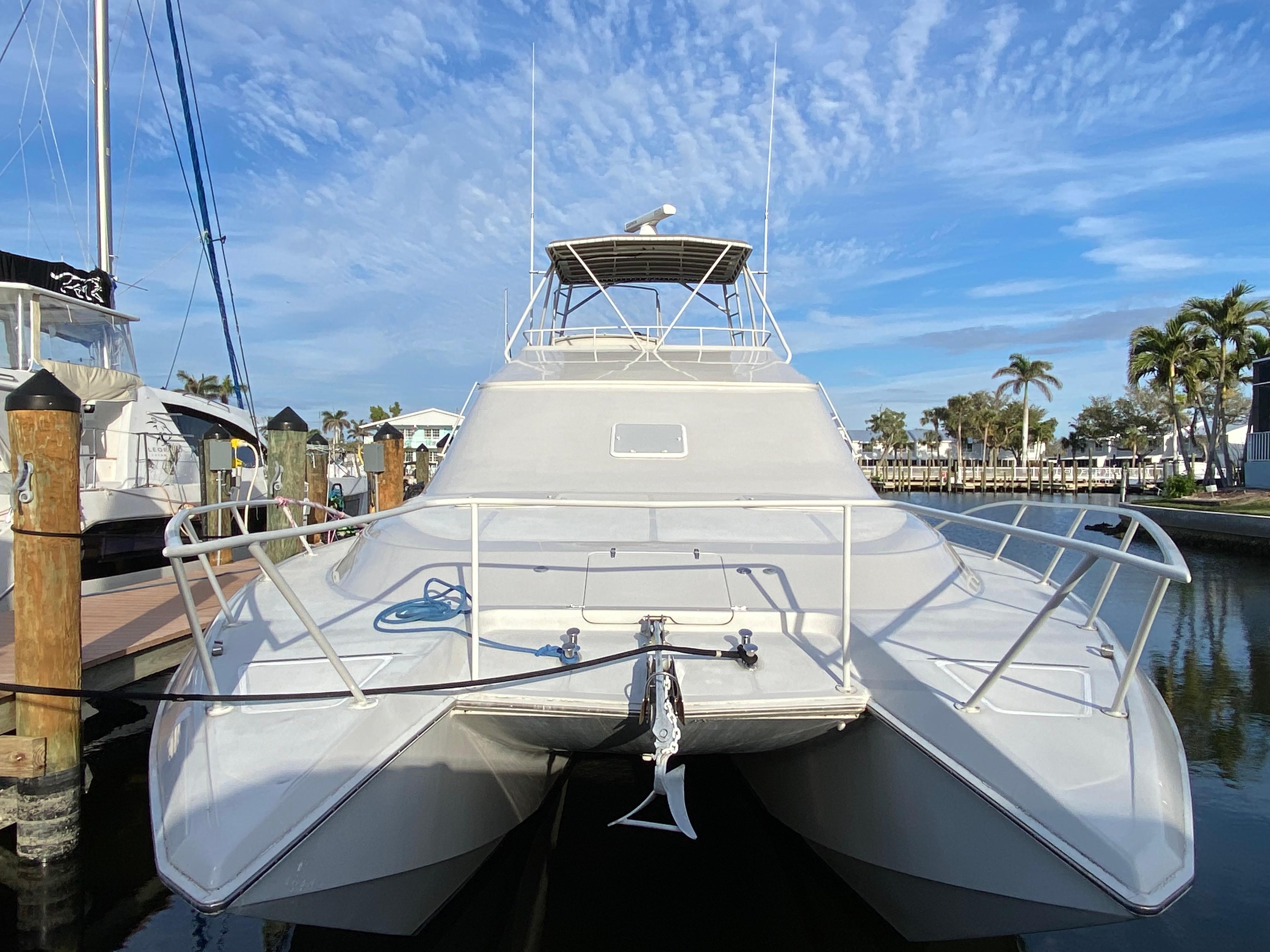 1995 Mares 58 Power Catamaran docked, showcasing sleek design and spacious deck.