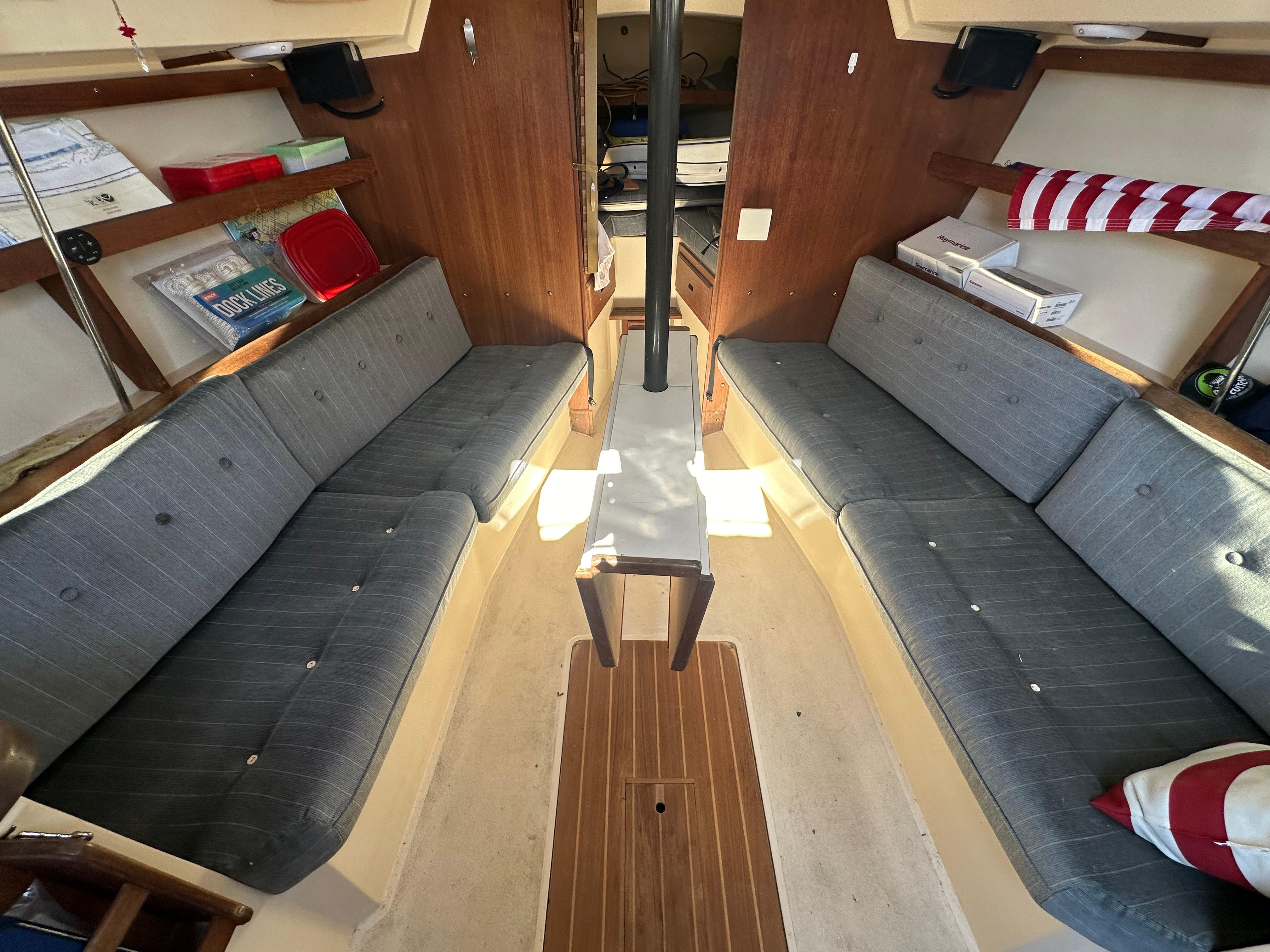 Interior of 1991 Catalina 28 sailboat with gray seating and wooden accents.
