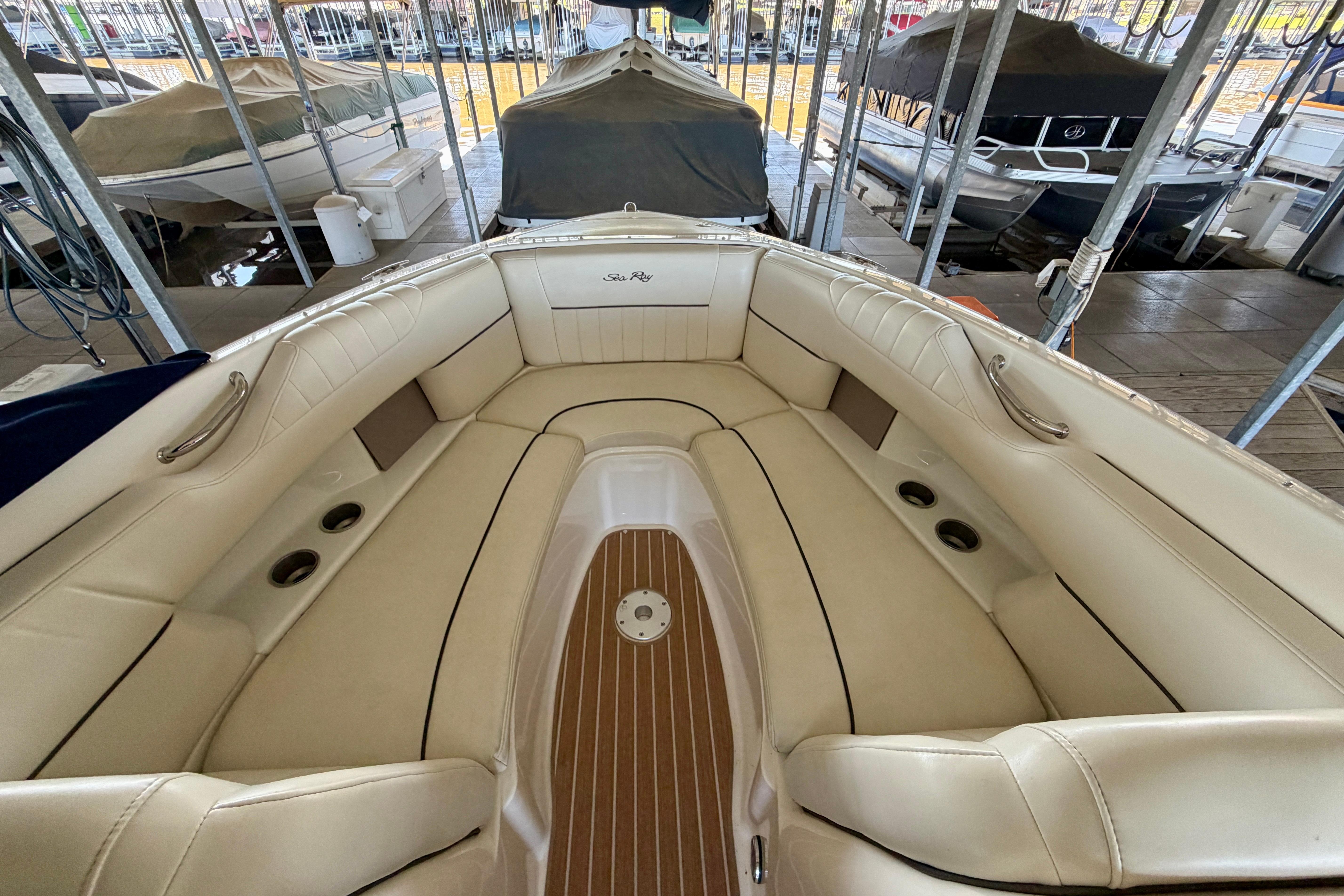 2007 Sea Ray 270 SLX boat interior with beige seating and wood accents in a marina.