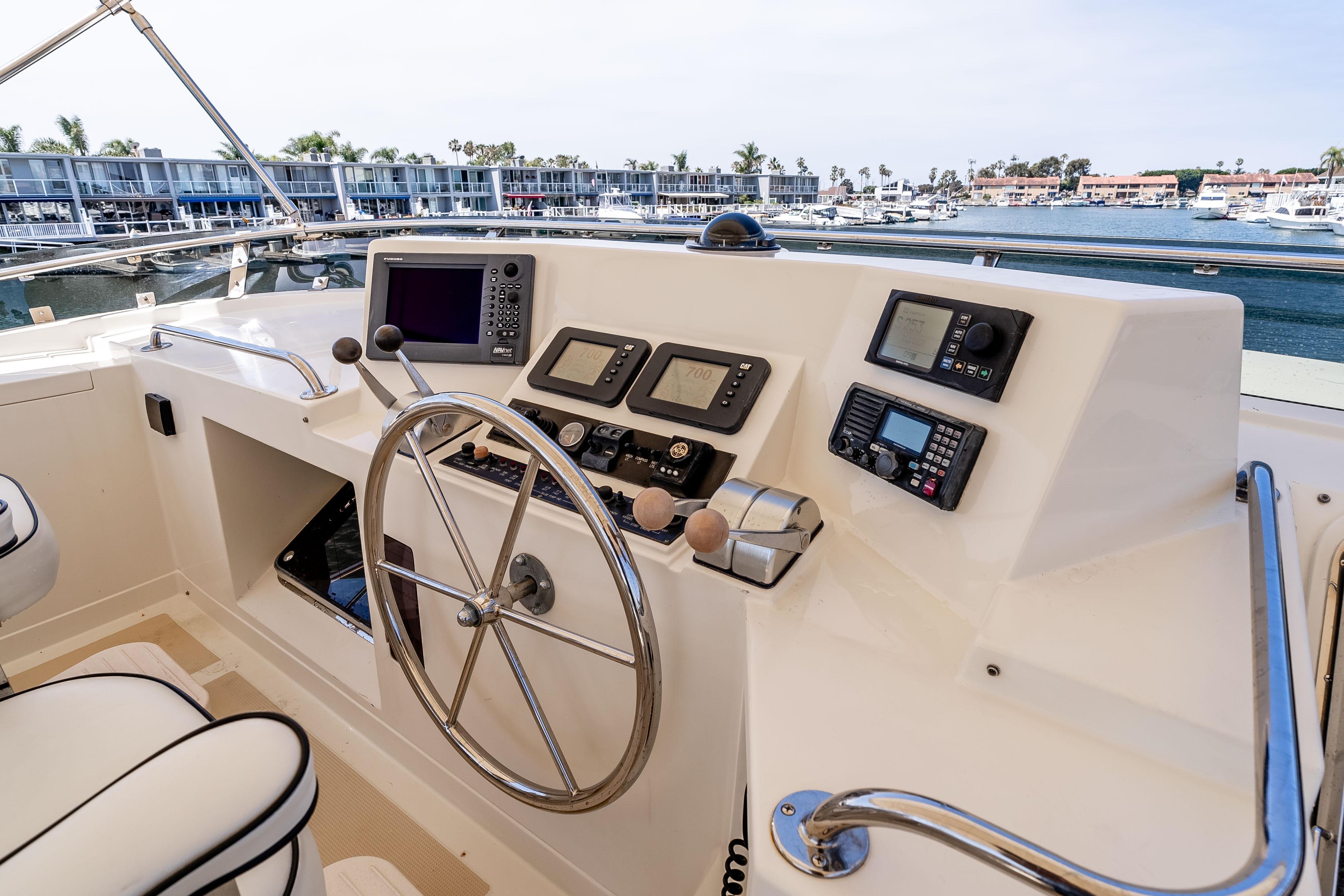 Pilothouse of 2005 Offshore Yachts 54, featuring navigation instruments and steering wheel.