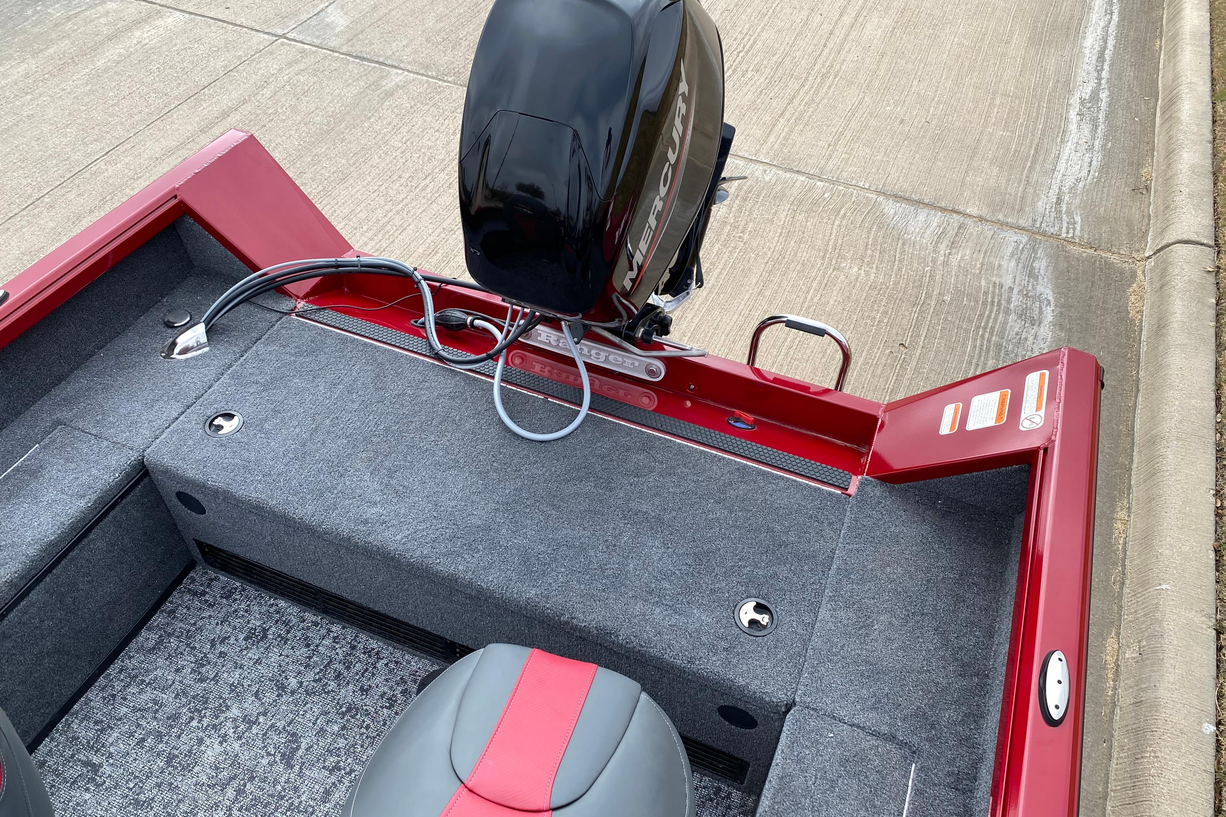2026 Ranger VS1665SC boat with Mercury engine, red and gray interior, parked on concrete.