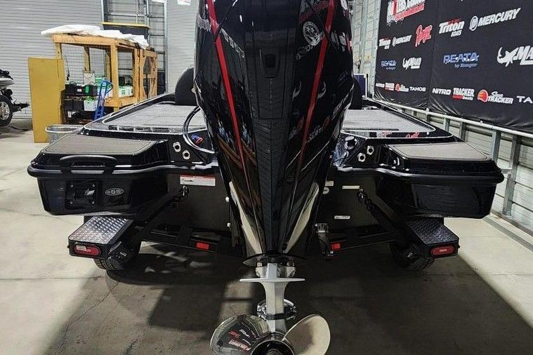2026 Triton 20XP Patriot boat in showroom, rear view with powerful engine.