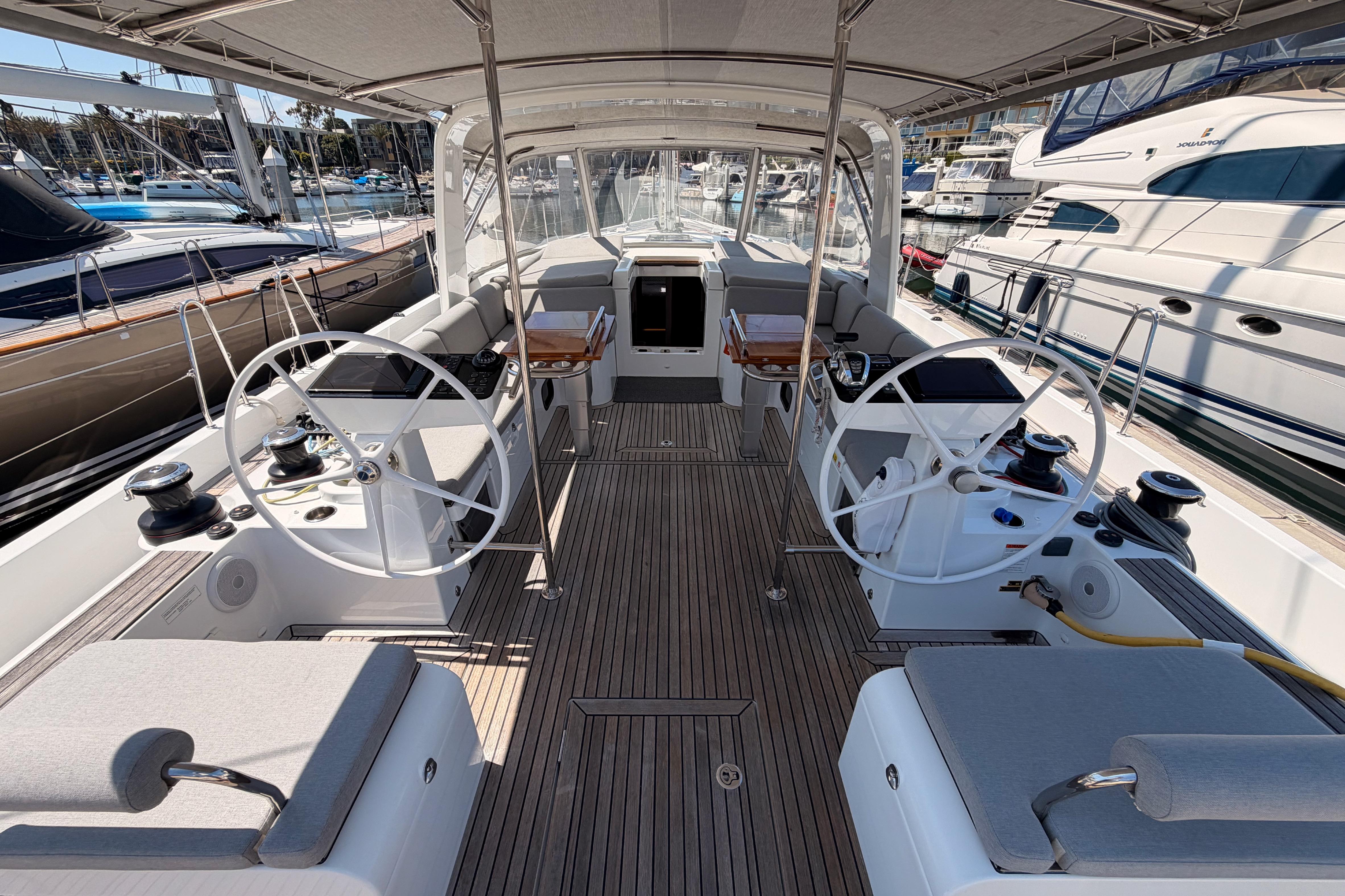 Spacious cockpit of 2022 Beneteau Oceanis Yacht 54 with dual steering wheels.