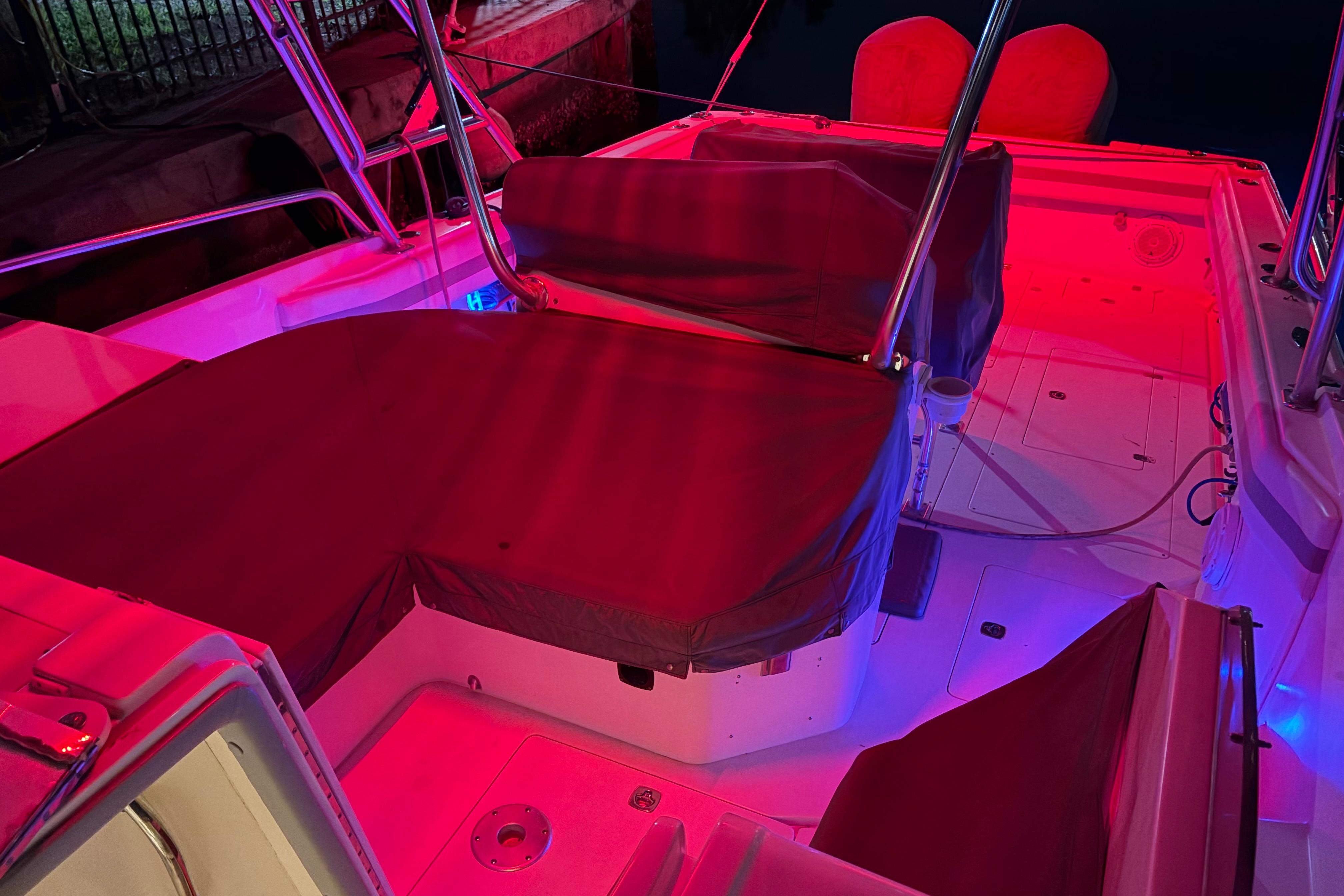1998 Intrepid 339 Walkaround boat interior with vibrant red lighting and covered seating.