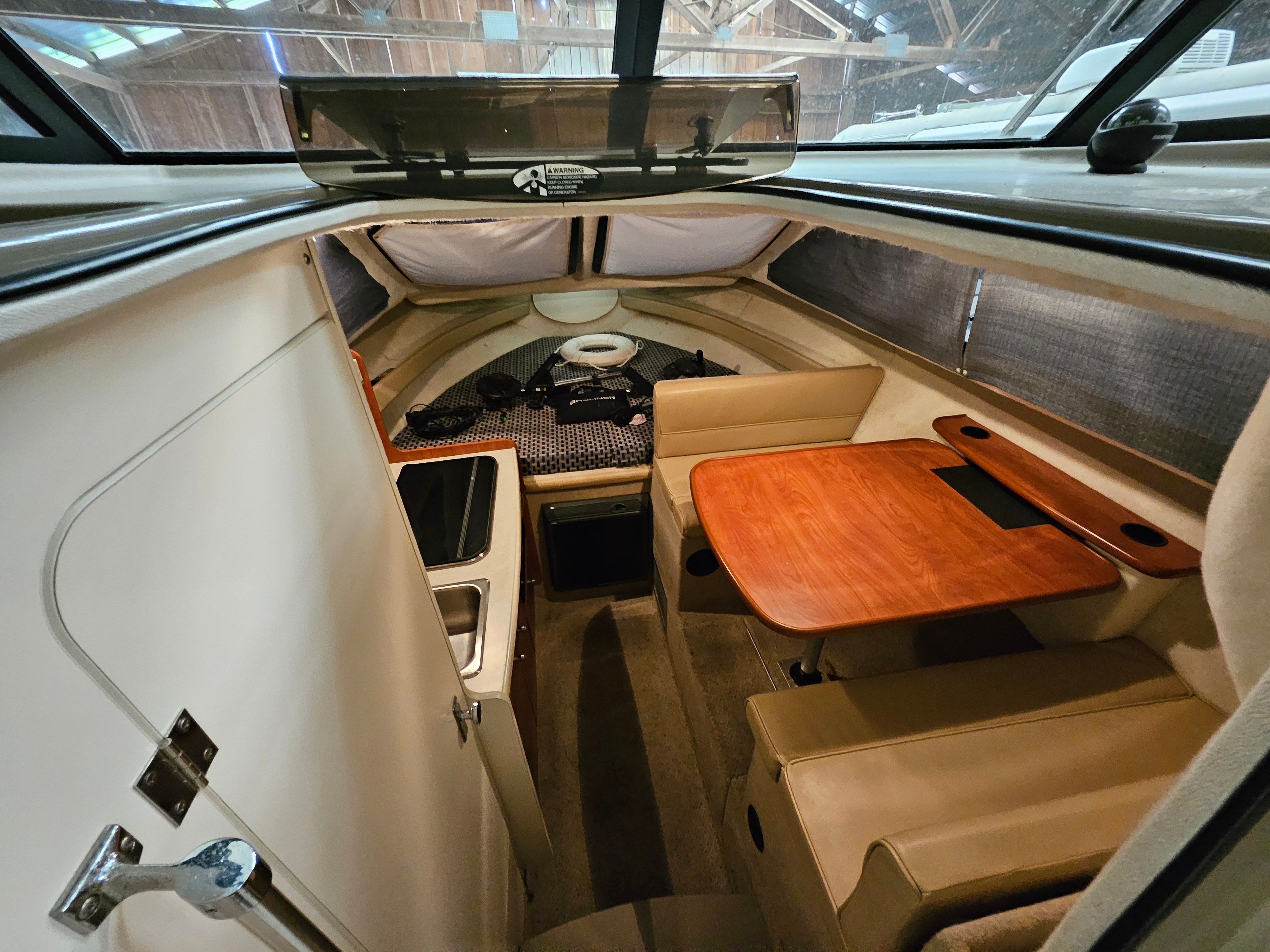 Interior of a 2005 Bayliner 242 Ceara with a table and seating area.