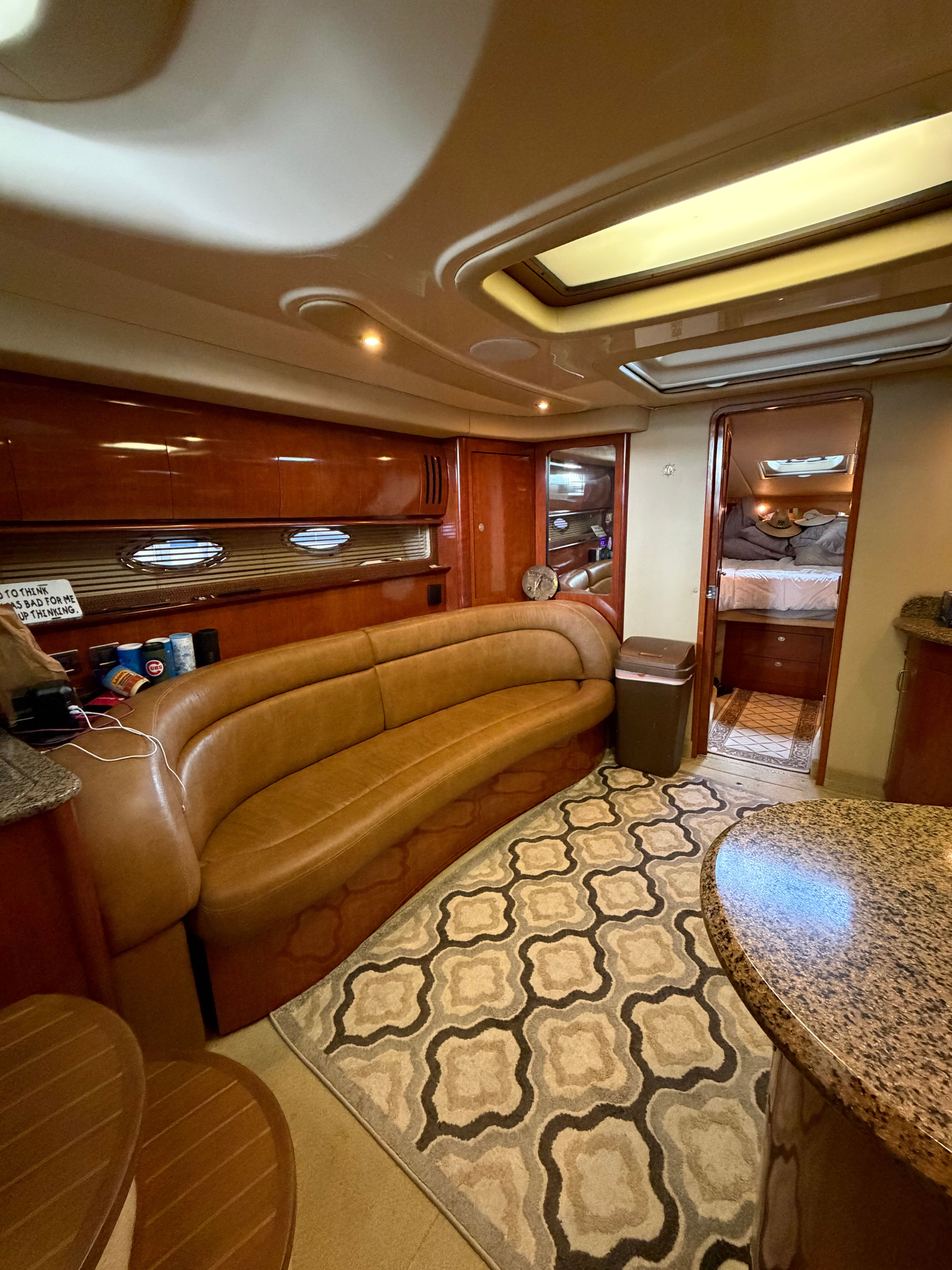 Interior of a 2005 Sea Ray 420DA with leather sofa and carpet.