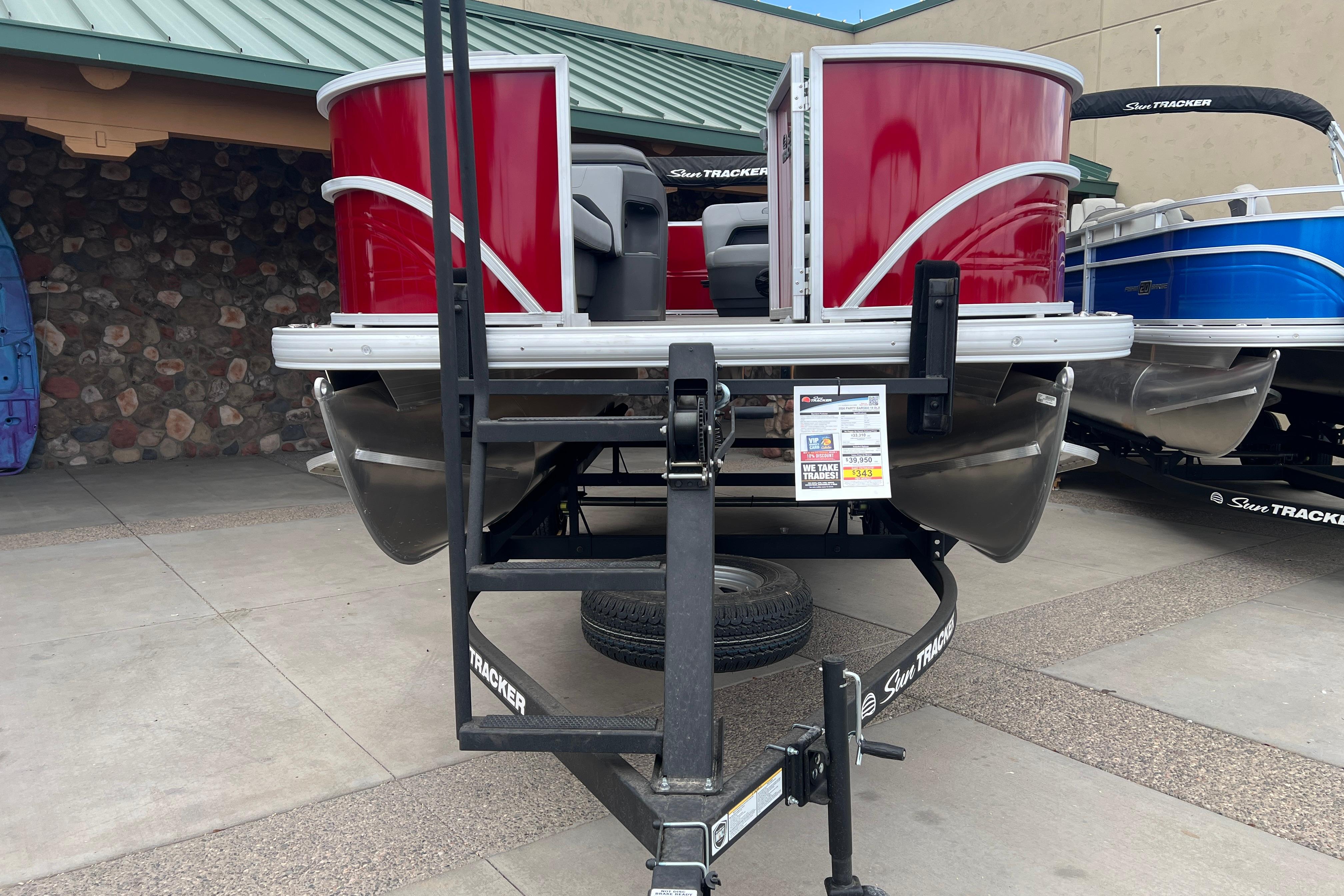 2026 Sun Tracker Party Barge 18 DLX pontoon boat on trailer, displayed outdoors.