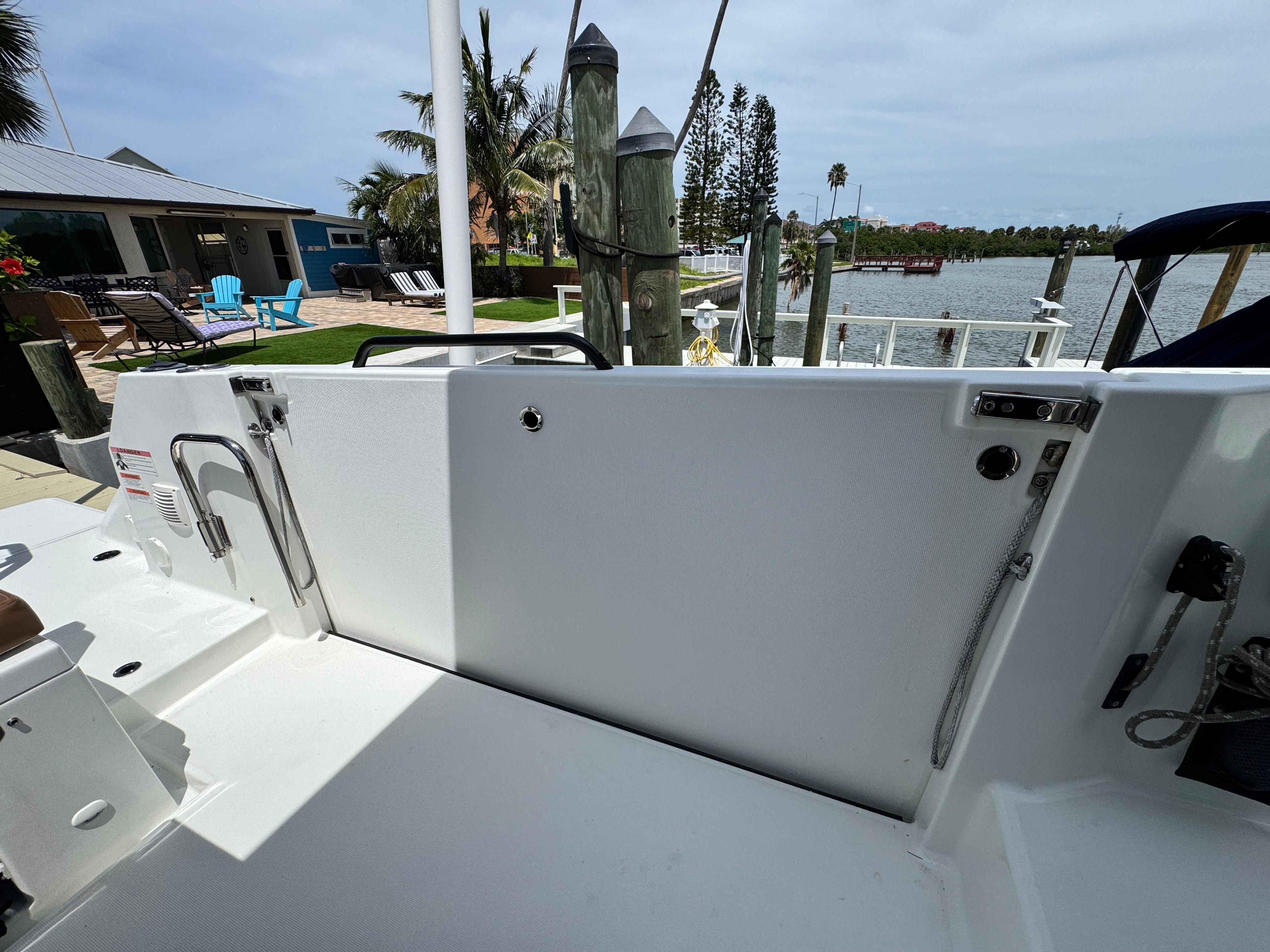 2022 Beneteau Flyer 9 SUNdeck boat docked near waterfront with palm trees.