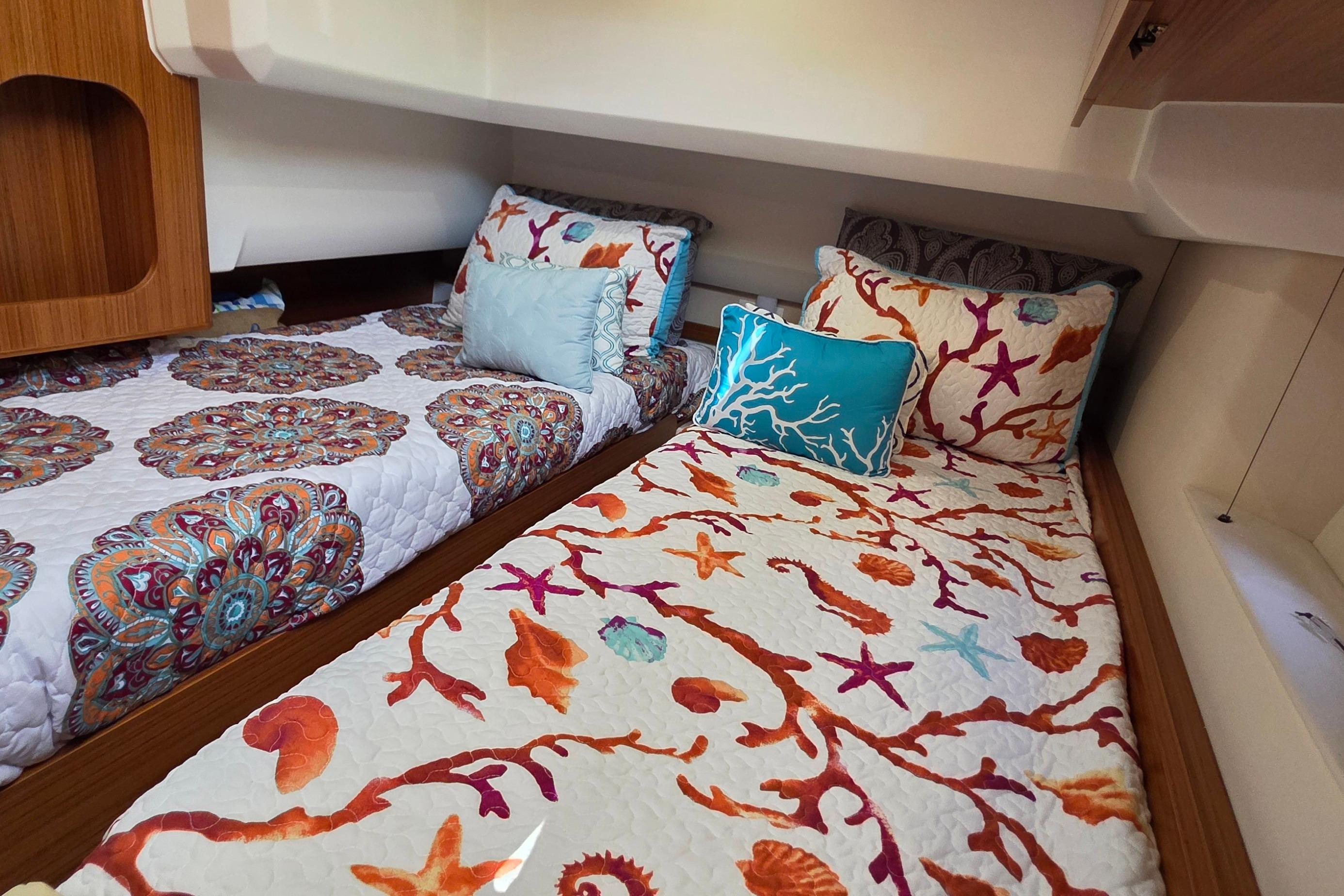 Cozy cabin interior of 2023 Greenline 40 yacht with vibrant bedding and pillows.