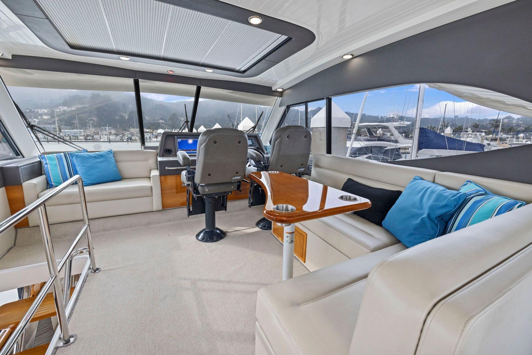Luxurious interior of 2014 Maritimo M50 yacht with plush seating and helm station.