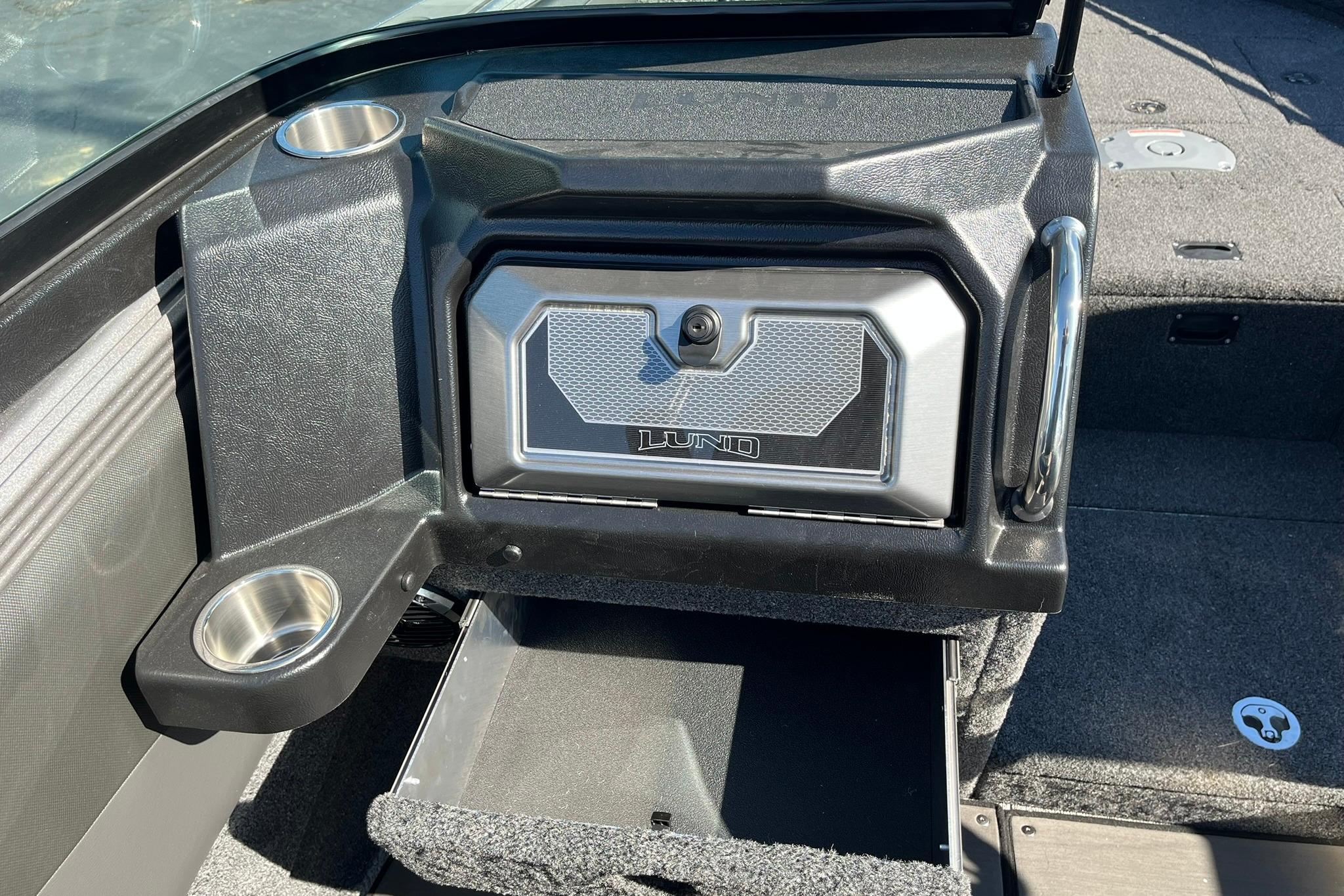 2026 Lund 2275 Baron boat interior with storage compartment and cup holders.
