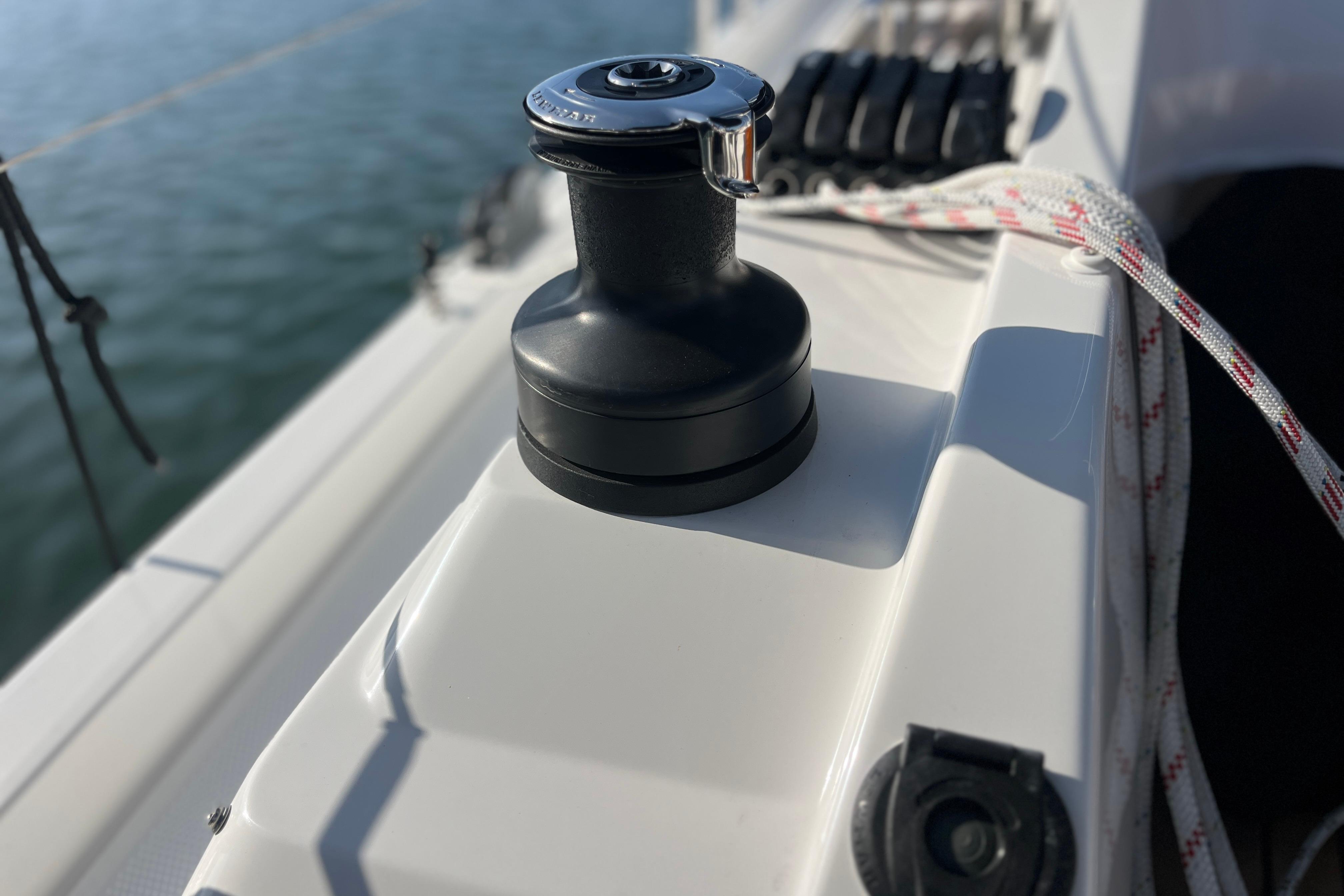 Winch on 2025 Hanse 360 sailboat deck with rope, near water.