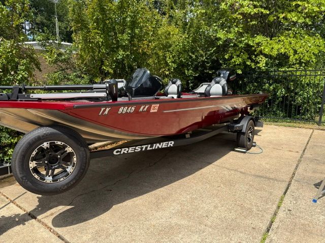 A red Crestliner XF 179 boat from 2024 is on a trailer in a paved area.