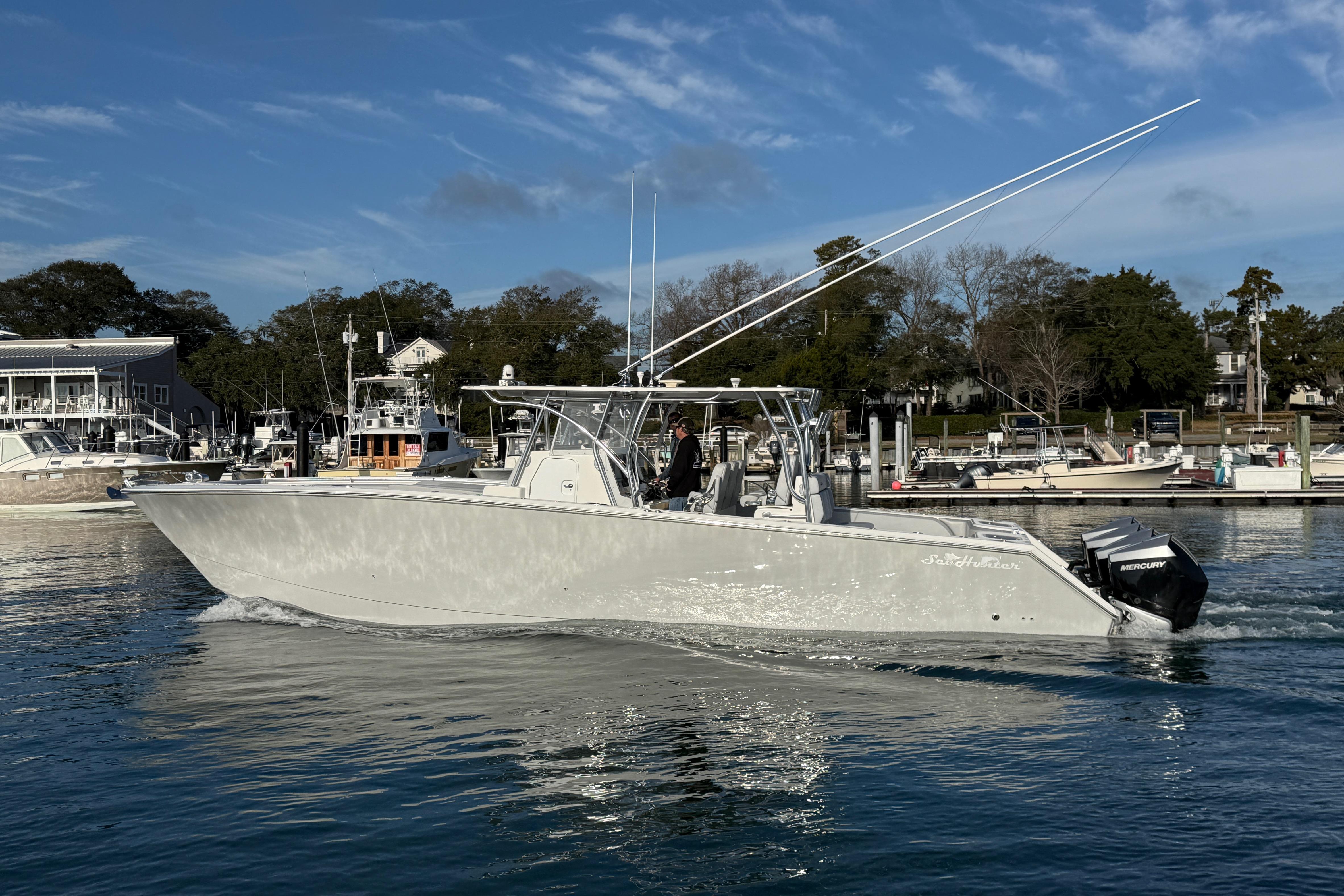 2021 SeaHunter 41 CTS boat cruising on calm water near a marina.