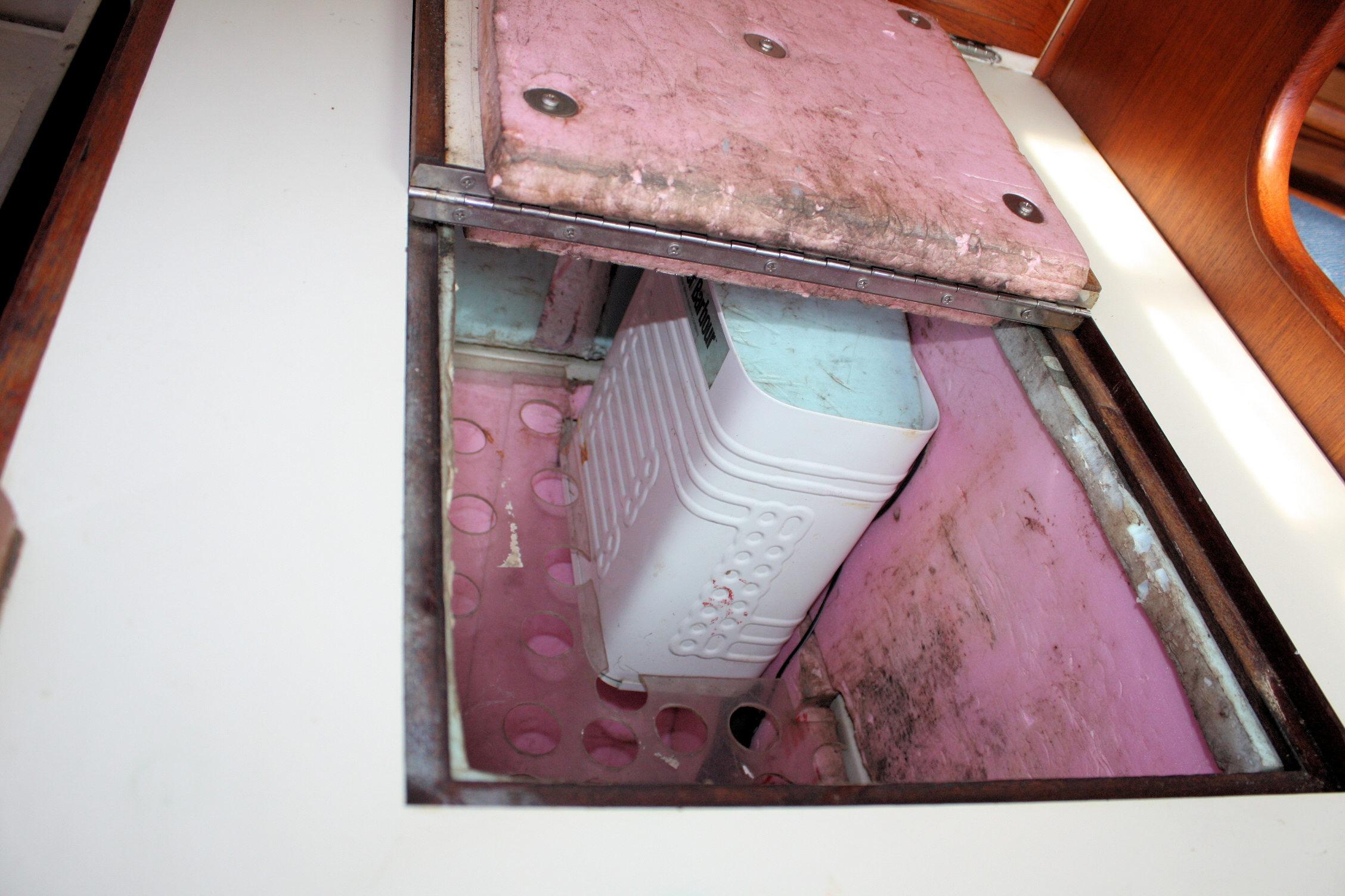 Open hatch on 1987 Ericson 38-200 sailboat revealing storage compartment.