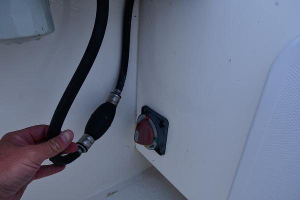 Hand holding a fuel line in a 2021 Eastern 248 Center Console boat.