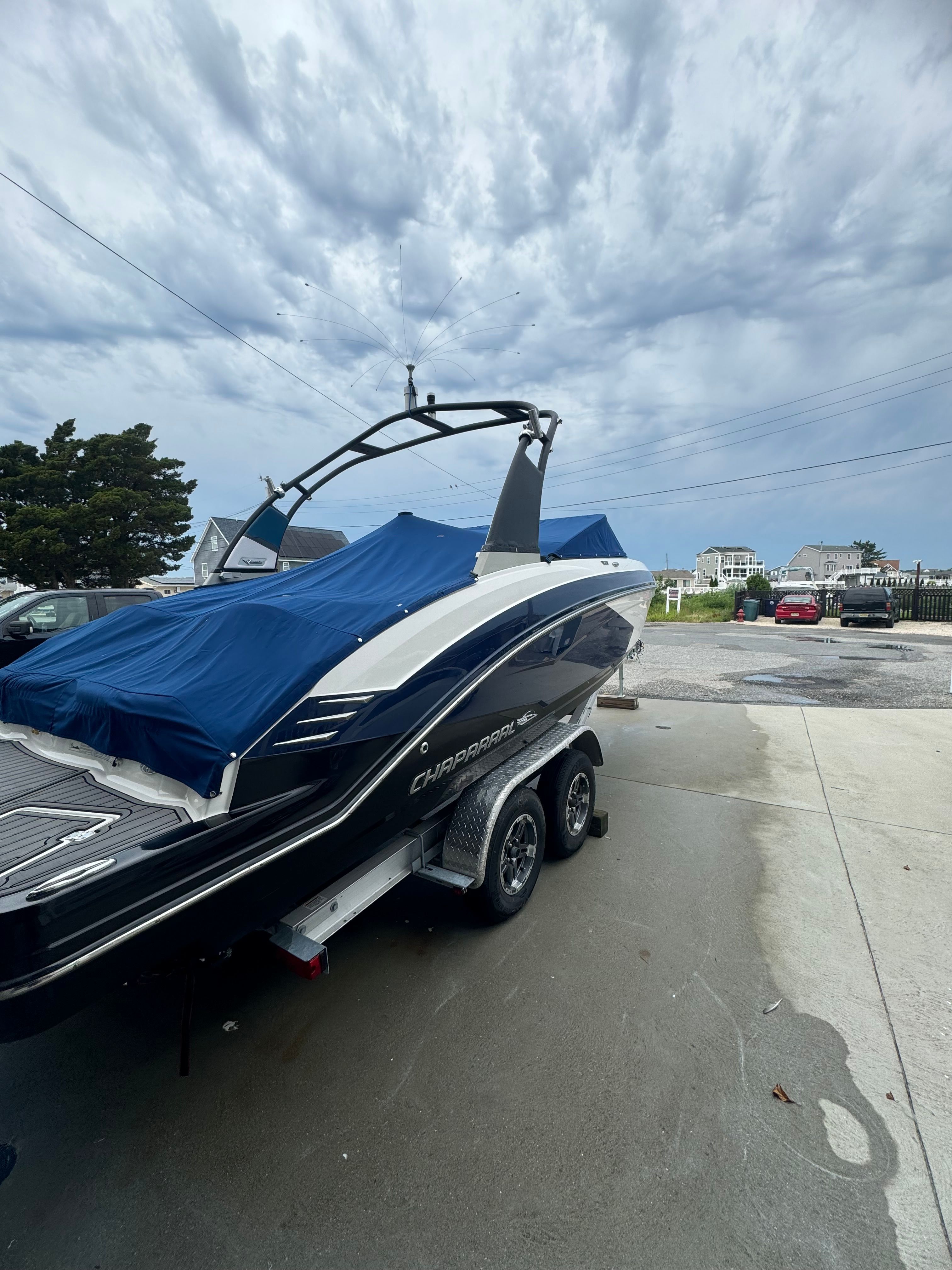 A 2016 Chaparral Vortex 243 VRX on a trailer, surrounded by houses and trees.