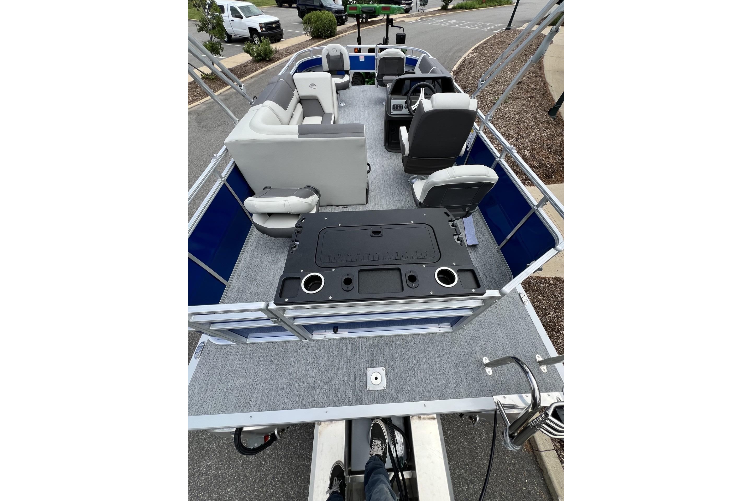 2026 Sun Tracker Fishin' Barge 20 DLX pontoon boat interior with seating and fishing station.
