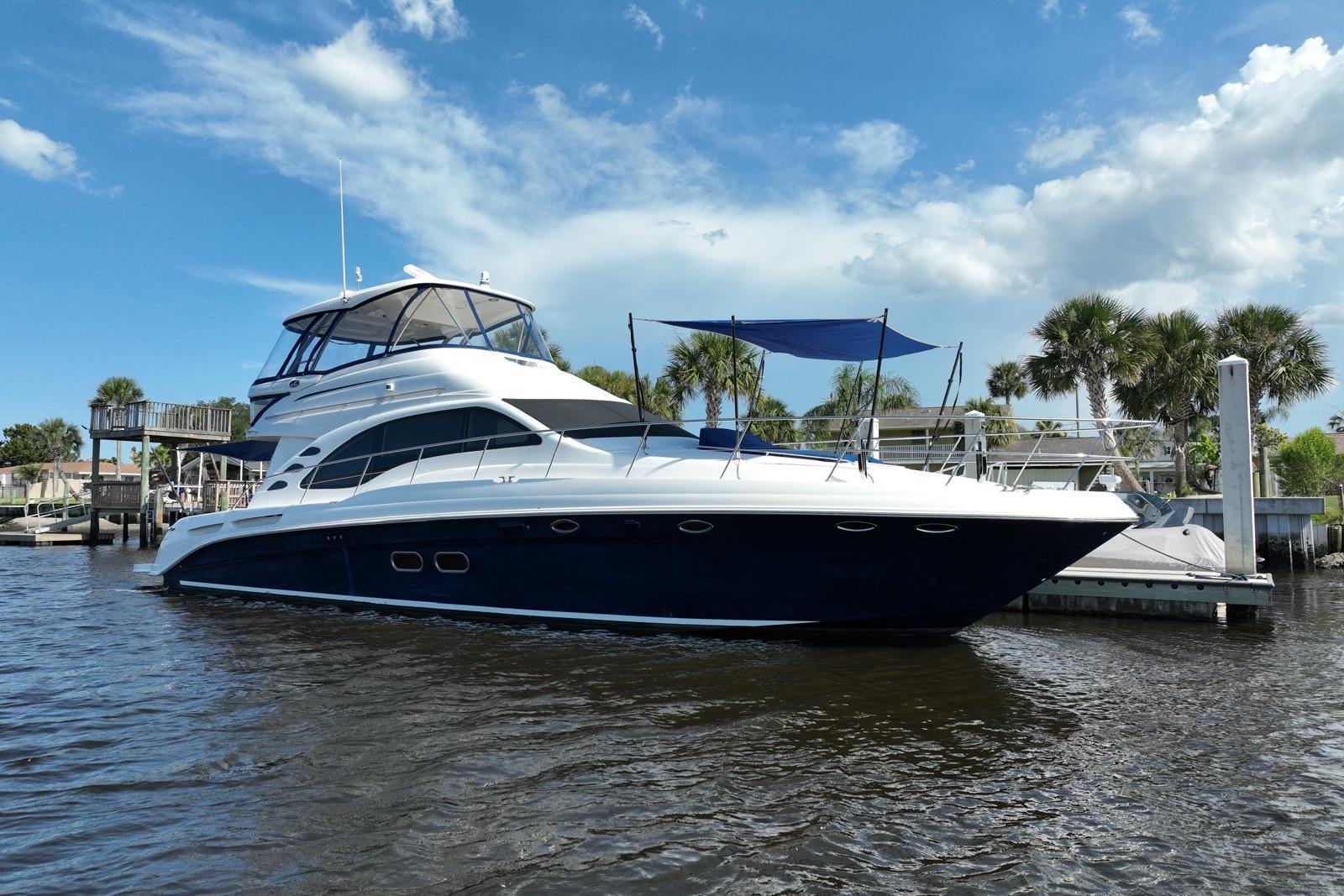 2006 Sea Ray 580 Sedan Bridge yacht docked on a sunny day with palm trees.