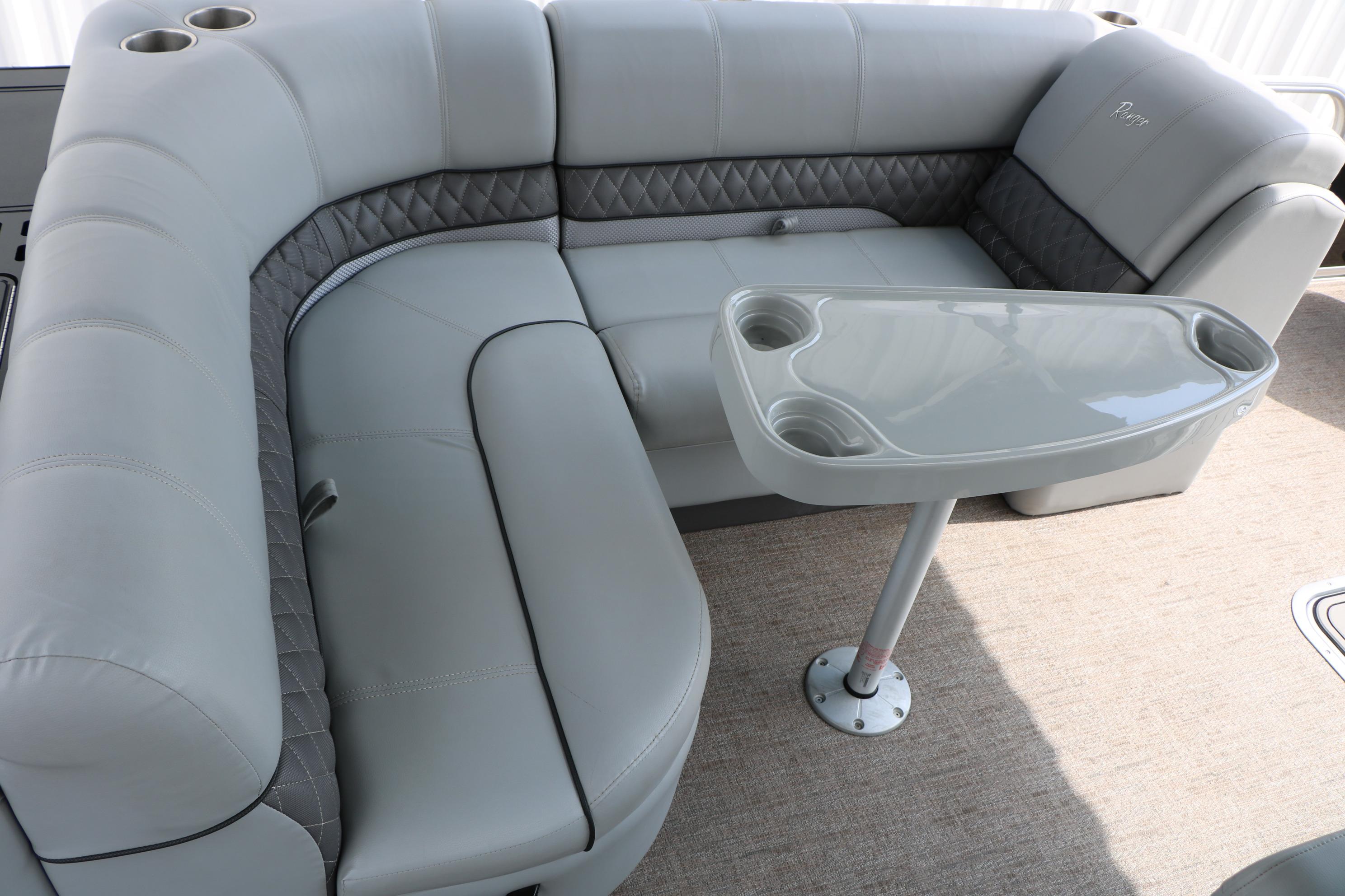 Luxurious seating area on 2021 Ranger 223FC boat with table and cup holders.