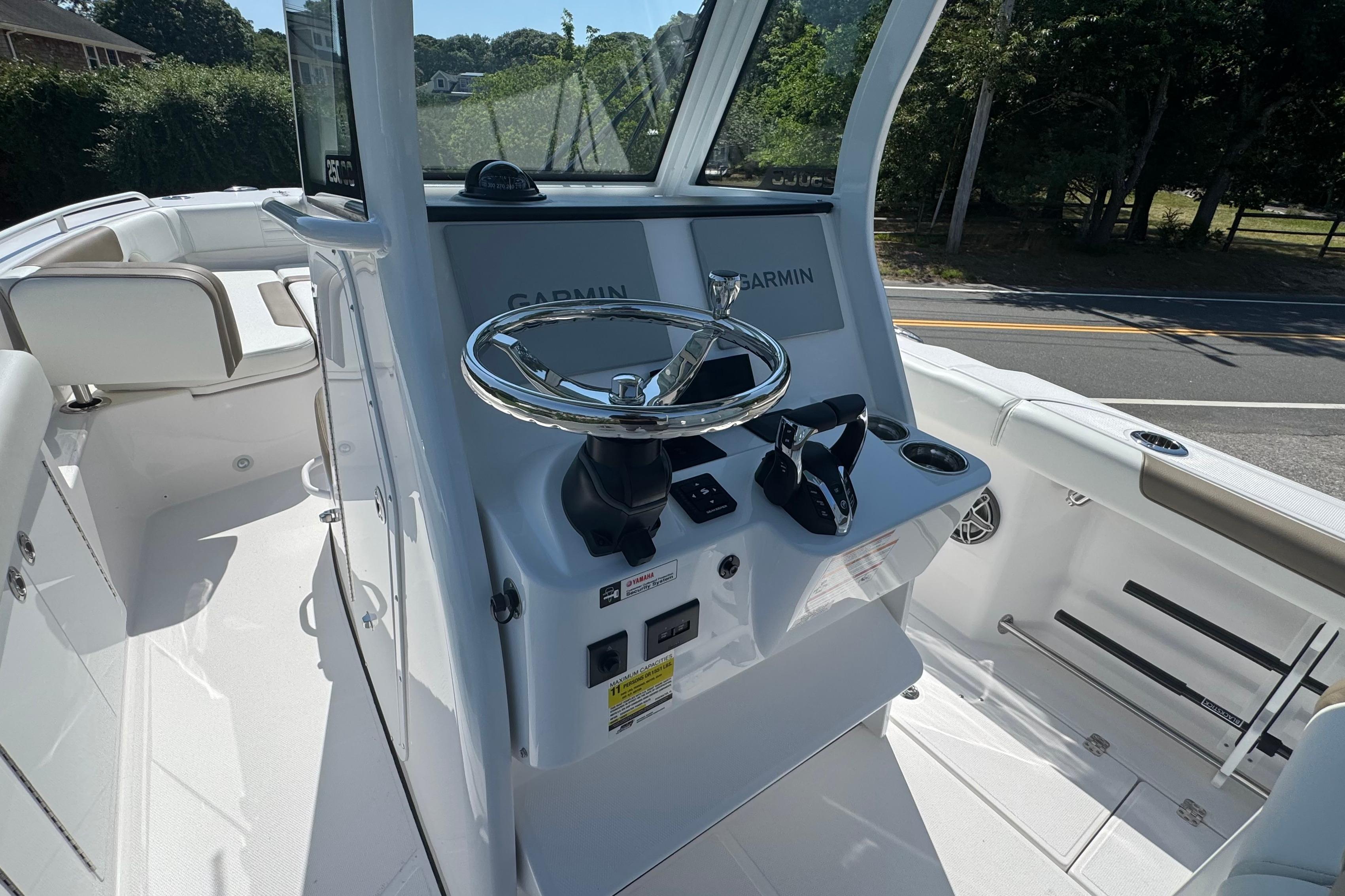 2026 Edgewater 250CC boat cockpit with Garmin navigation system and sleek steering wheel.