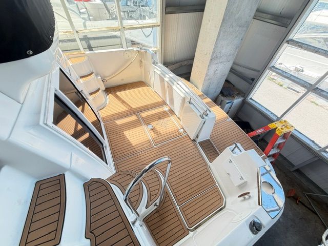 The image shows the cockpit of a 2005 Carver 44 Cockpit Motor Yacht with wooden flooring.
