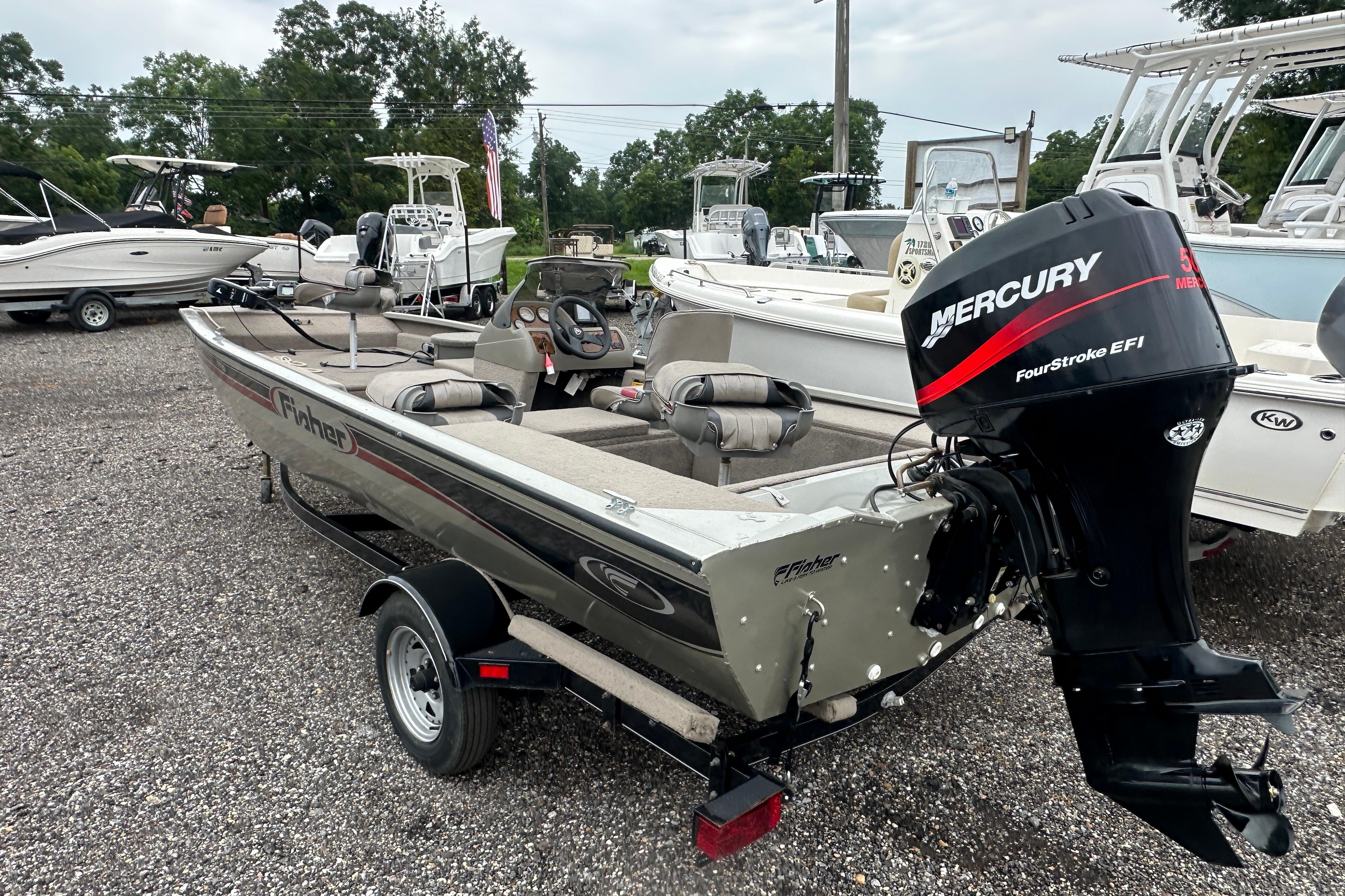 2002 Fisher 1710 boat with Mercury FourStroke EFI engine, parked on gravel lot.