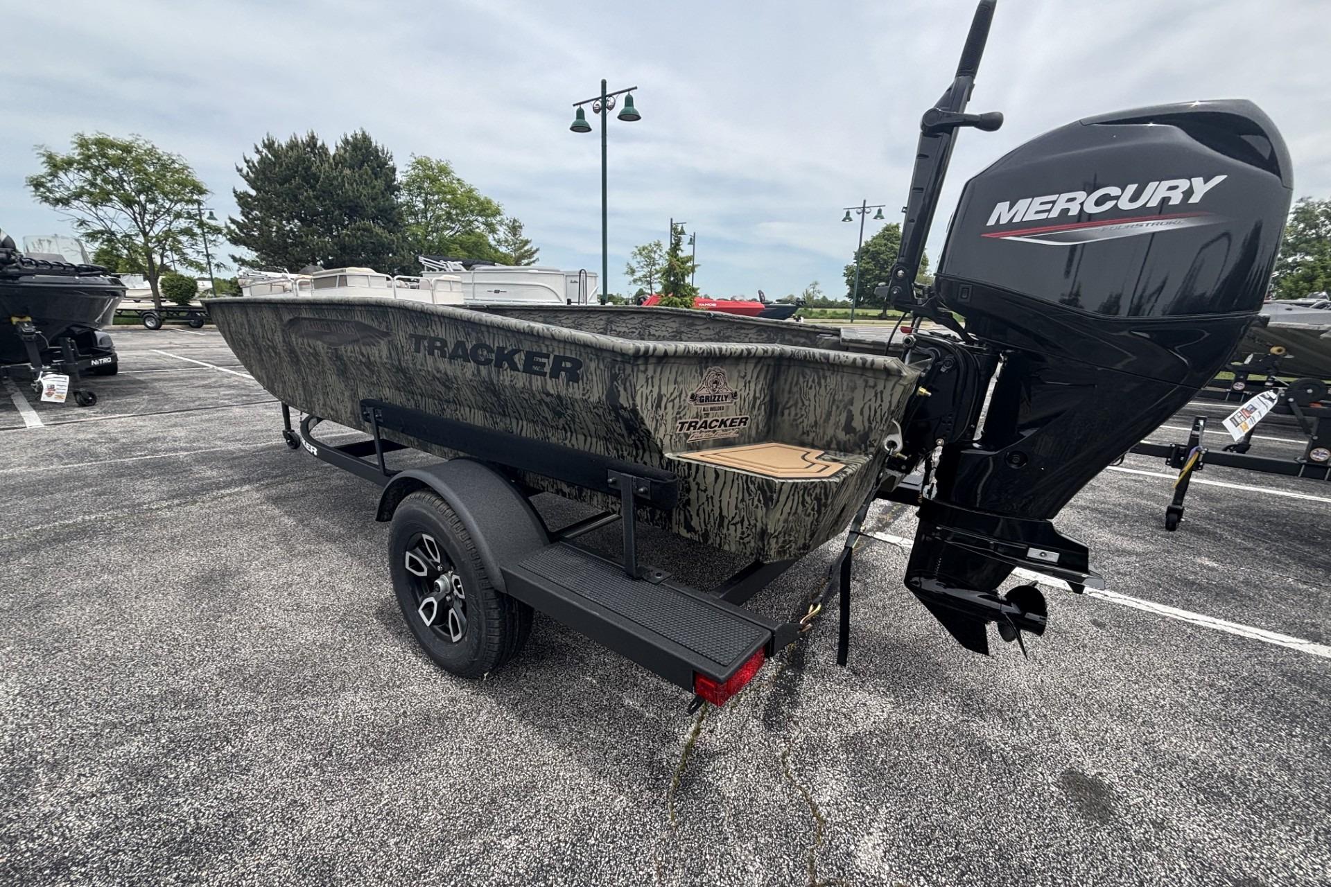2026 Tracker Grizzly 1650 T Prairie Wings Edition boat with Mercury engine in parking lot.