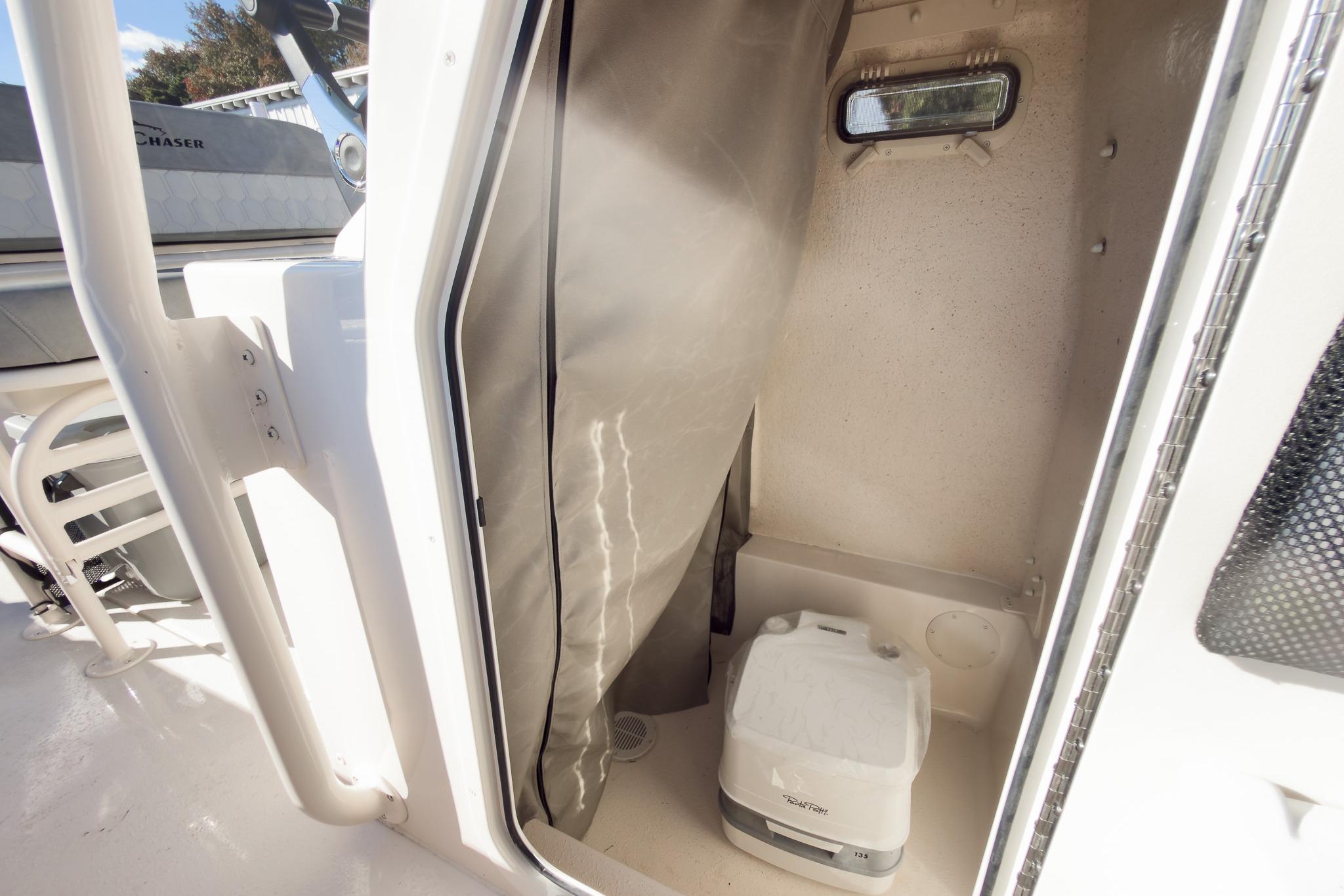 Interior of 2026 Sea Chaser 24 HFC DE boat with portable toilet.