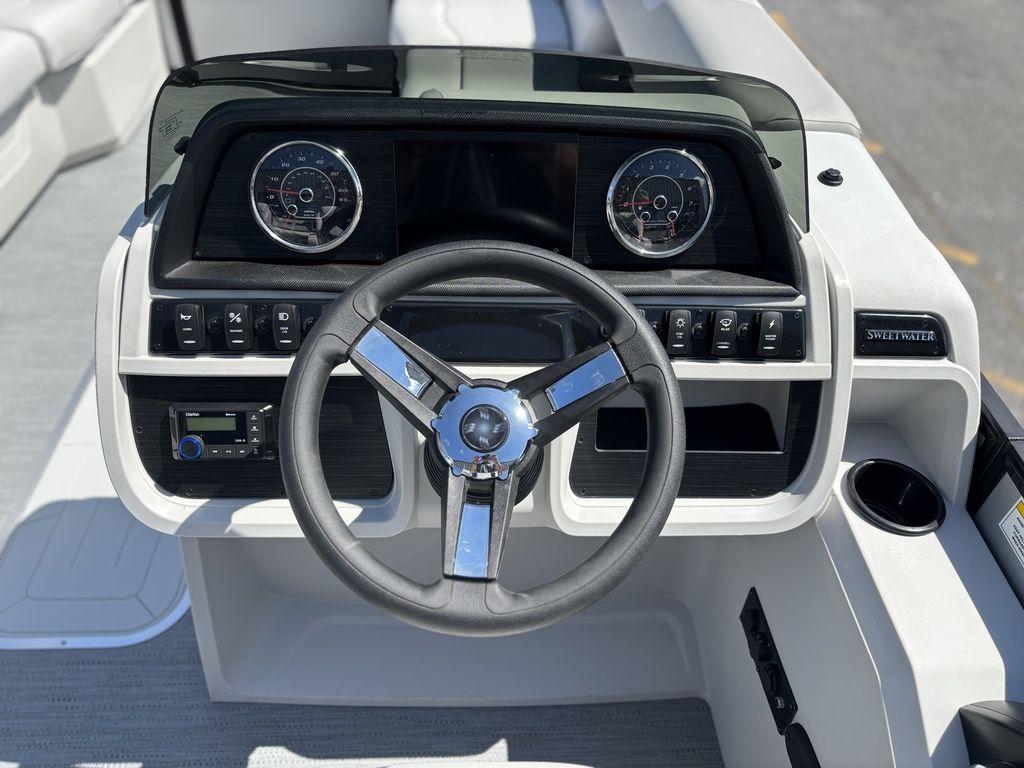Steering console of 2026 Godfrey SWEETWATER 2286 SFL boat with gauges and controls.